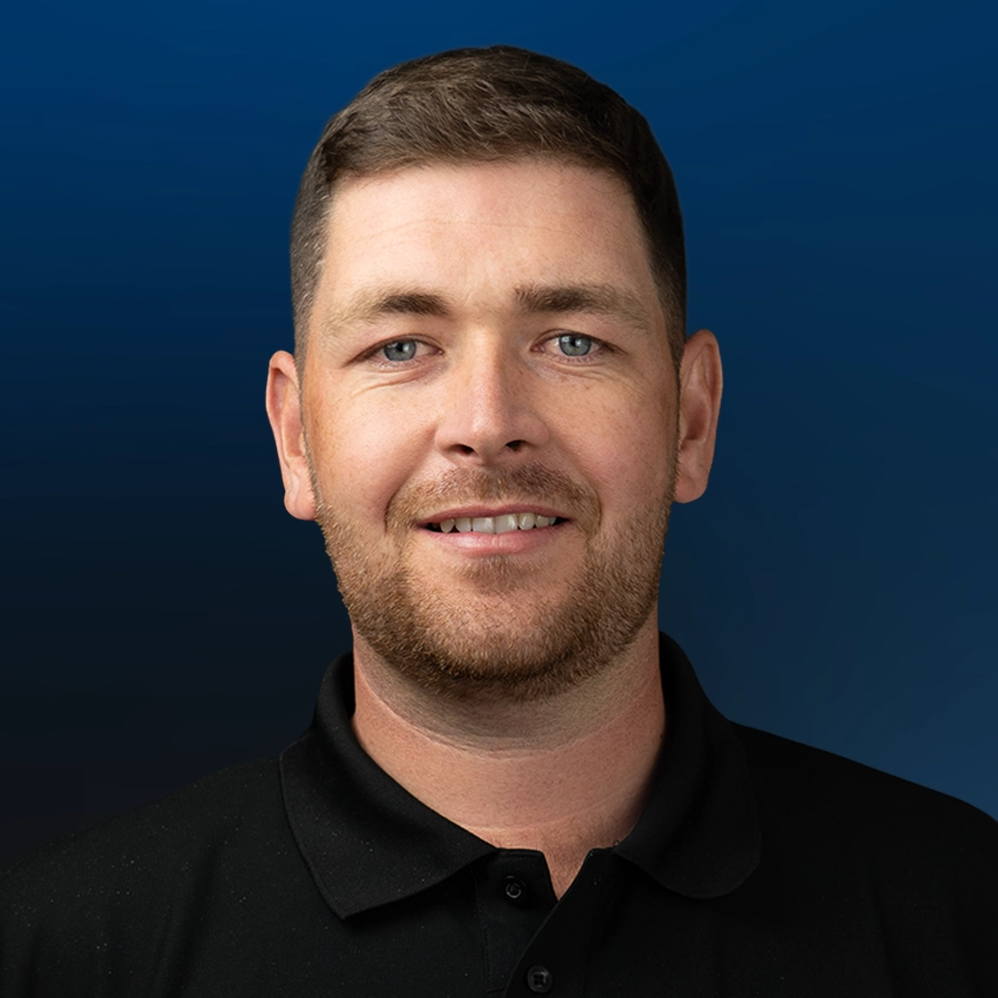 Professional headshot of Andrew Fox smiling against blue background