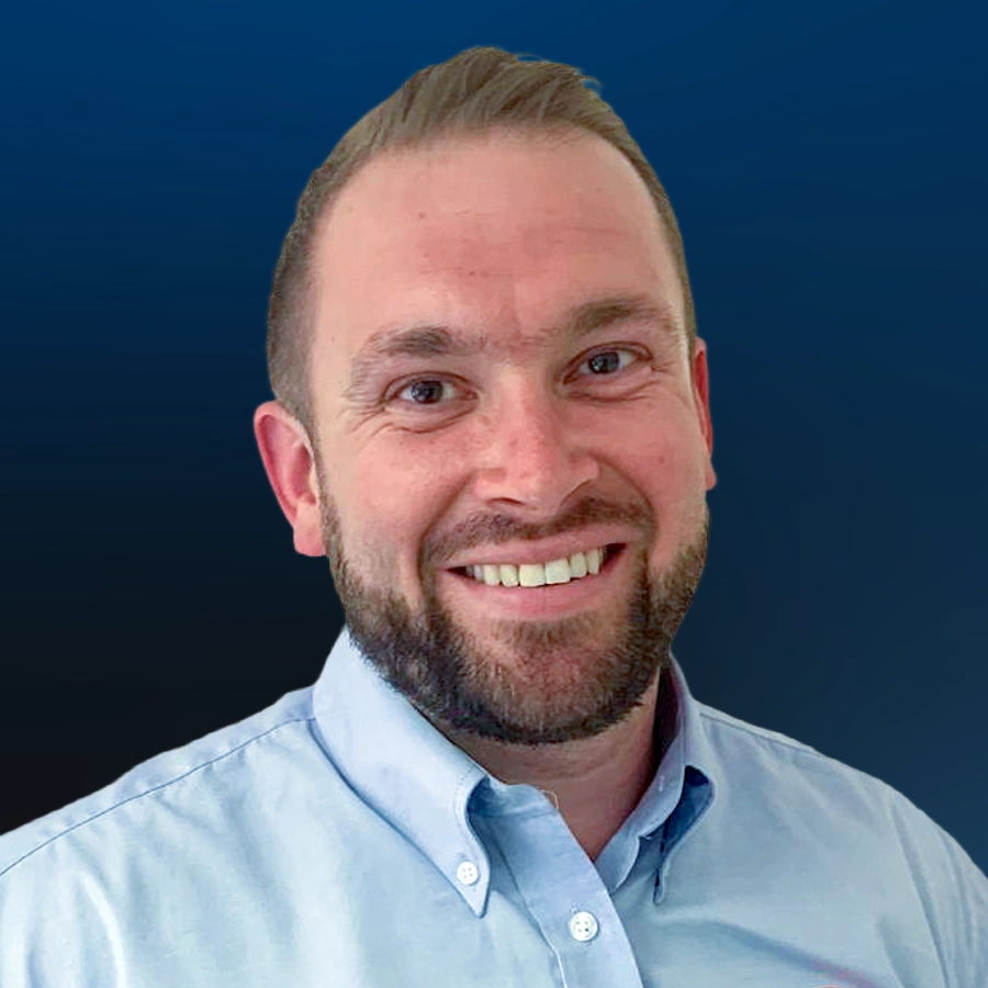 Professional headshot of bearded man wearing light blue button-up shirt