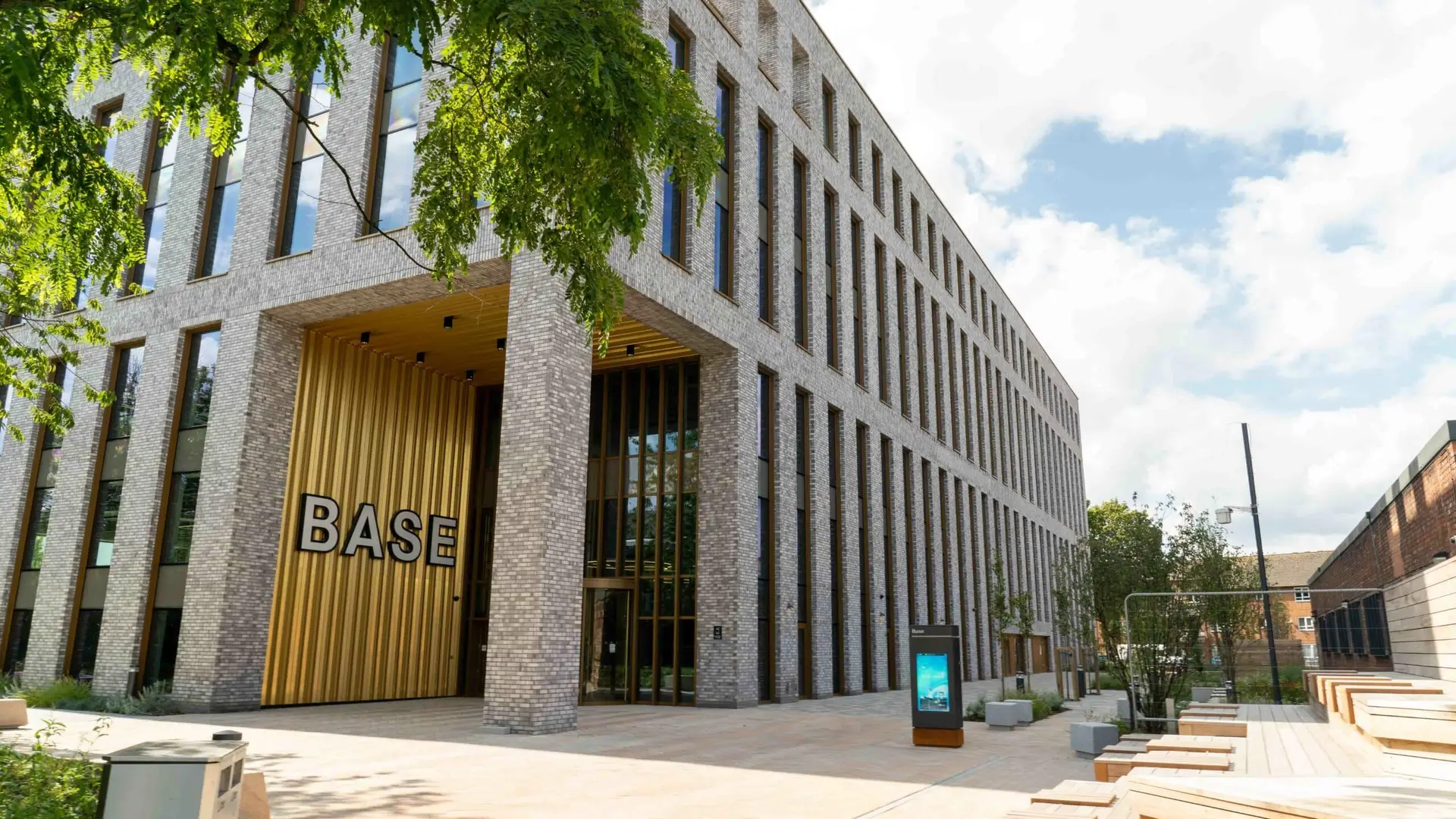 Modern brick building with golden entrance doors labeled BASE