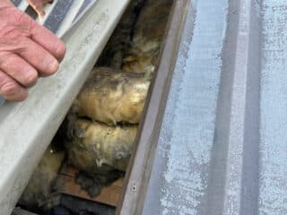 metal roof panel lifted to show insulation