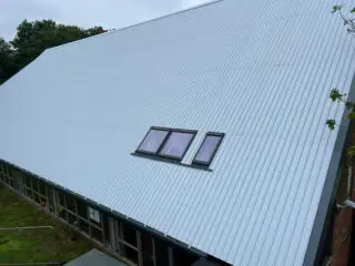 steep pitch metal clad roof profile system including skylight