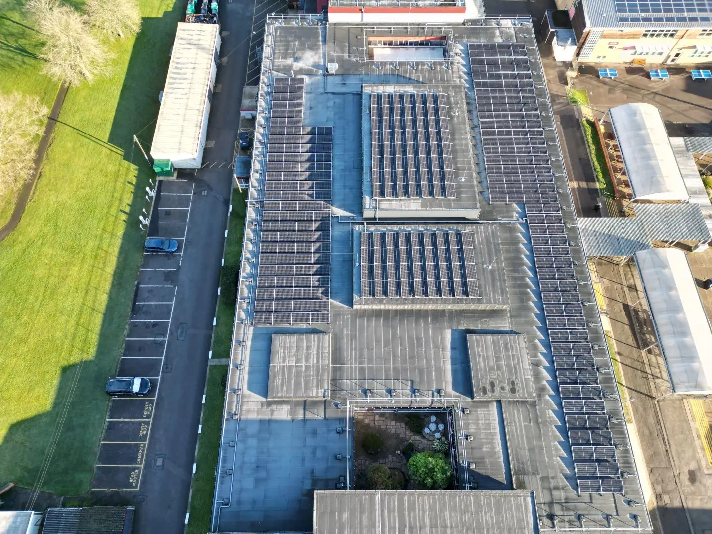 Aerial view of school building with extensive rooftop solar panel installation