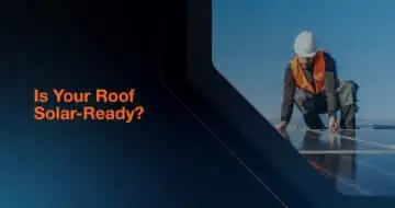 Worker wearing a helmet and high visibility vest on a roof installing solar panels, with the text Is Your Roof Solar Ready? on a dark blue background