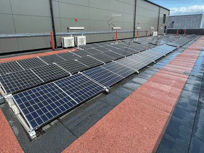 Solar panels installed on a flat roof with red walkway strips alongside