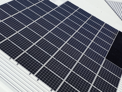 Close-up view of rows of solar panels installed on a white industrial roof