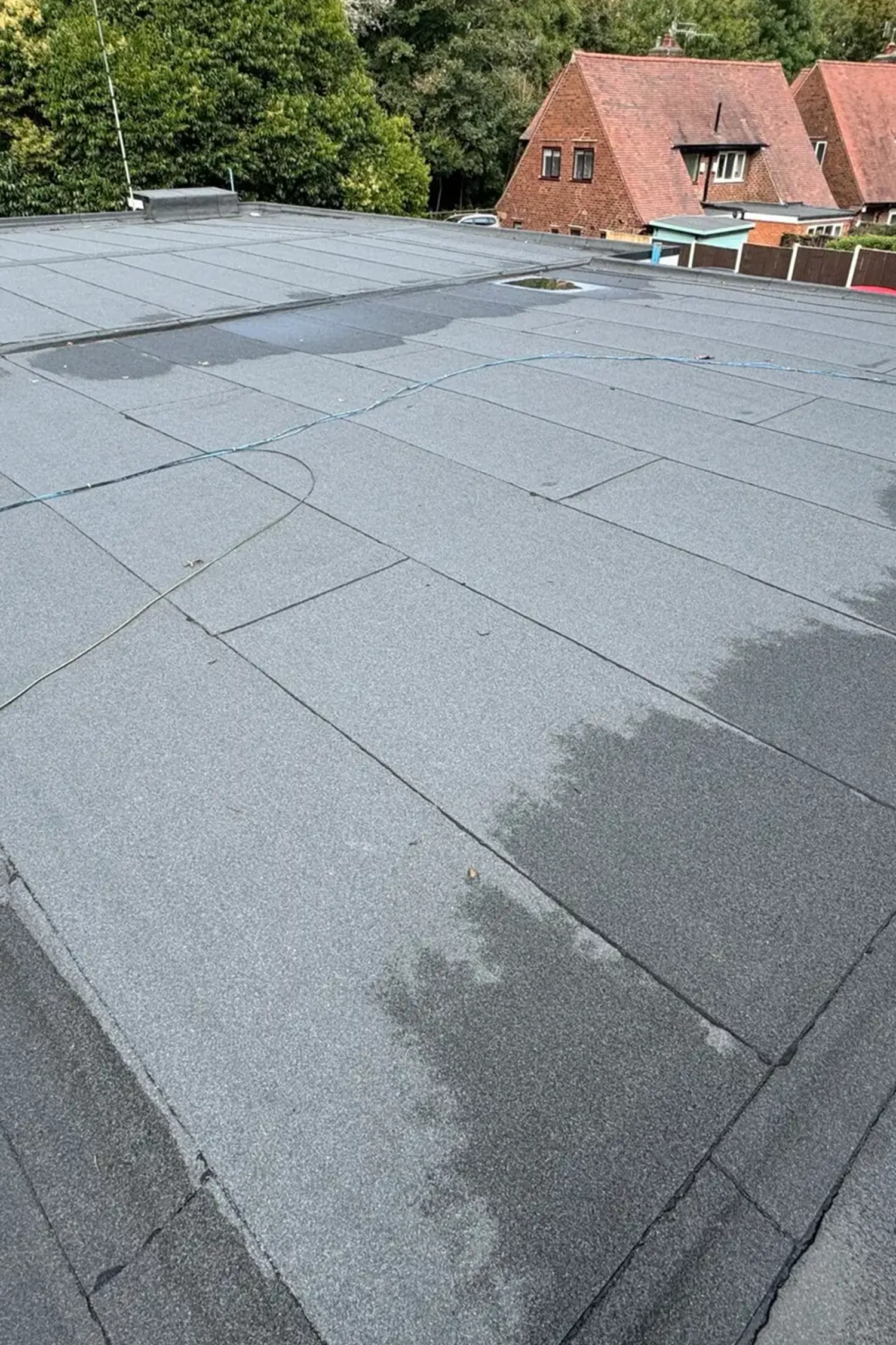 Flat roof with dark gray tiles and seams on ambulance station building