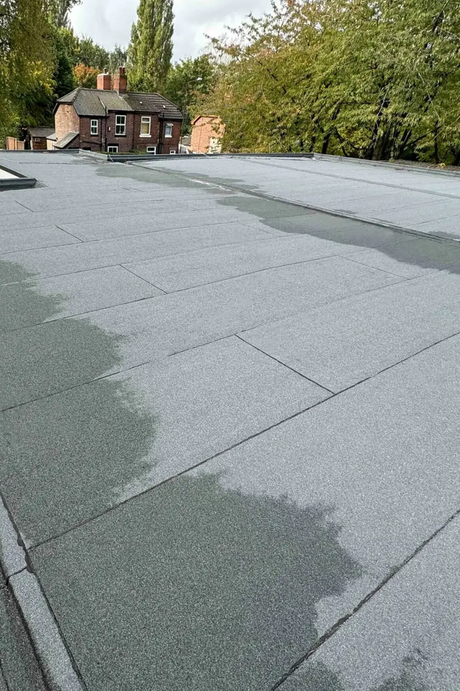 Flat roof with mineral surface covering on brick ambulance station building