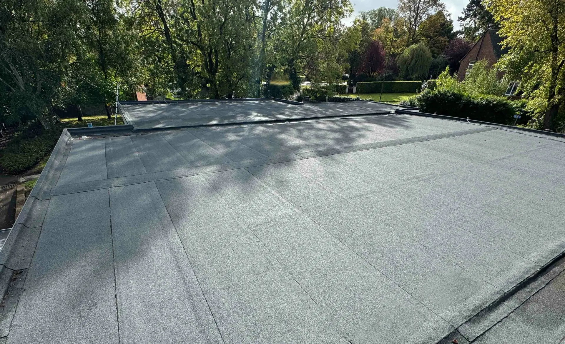 Newly installed flat roof with gray membrane covering ambulance station building