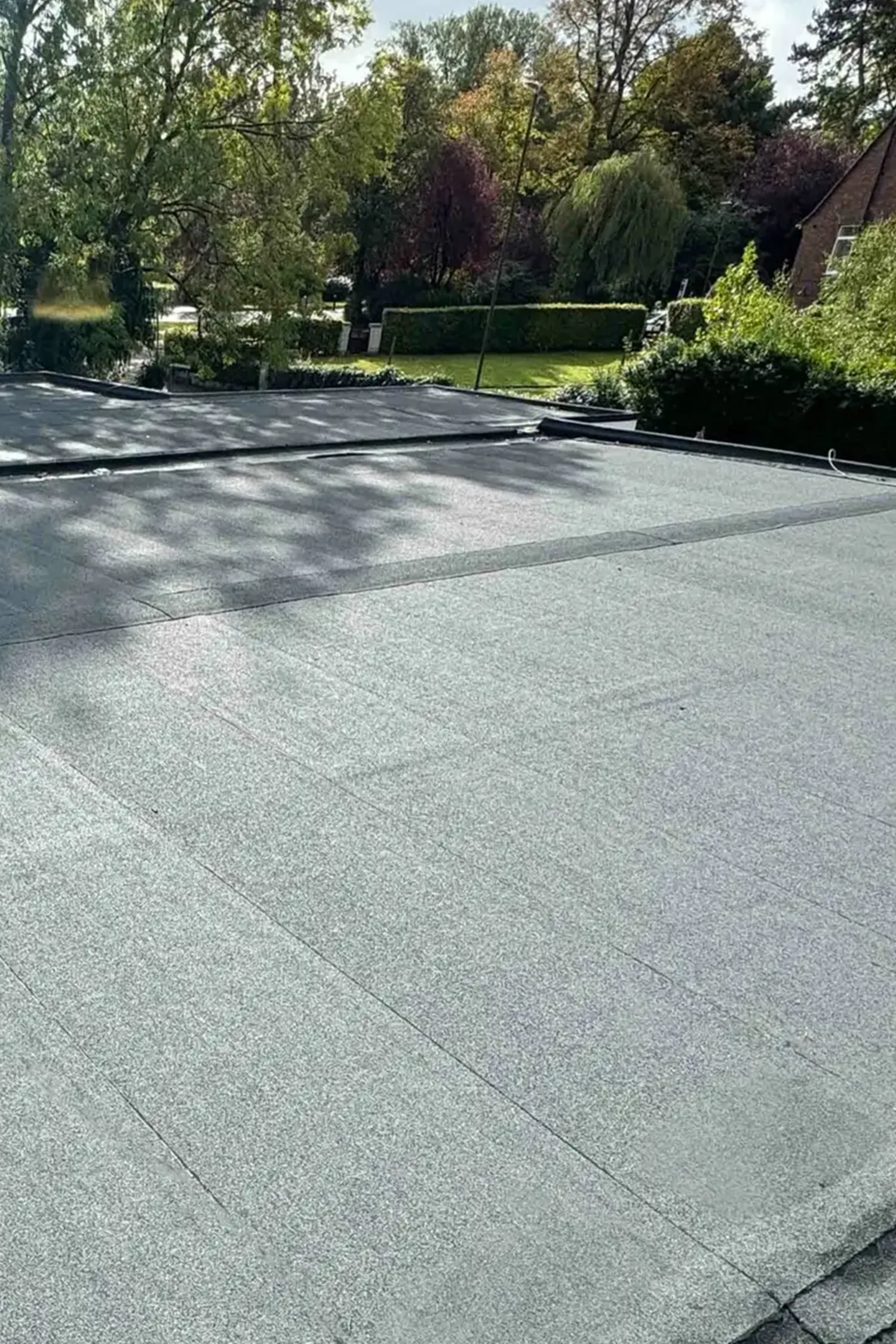New flat roof installation on ambulance station building with landscaping