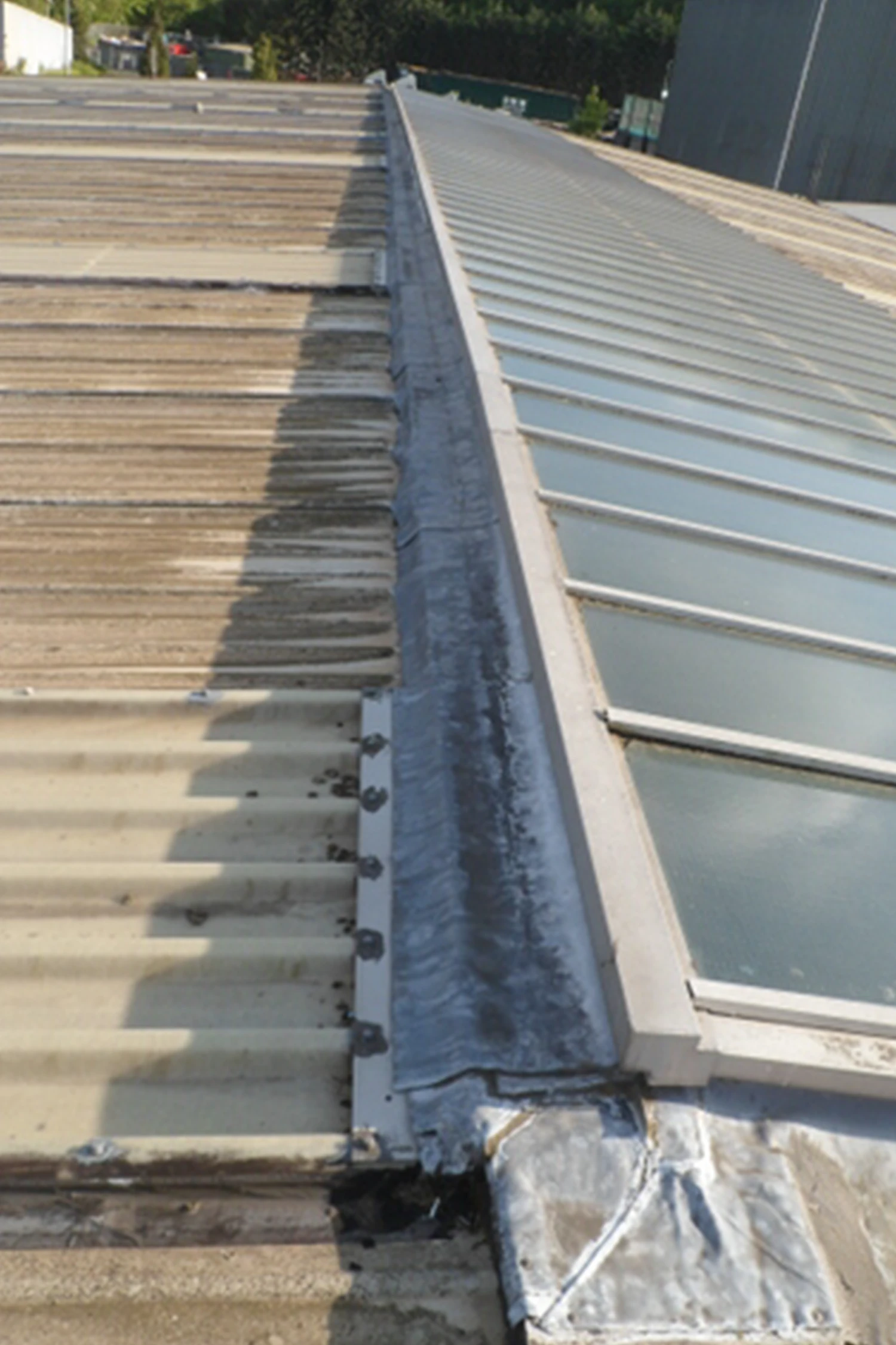 Standing seam metal roof installation alongside wooden deck roofing system
