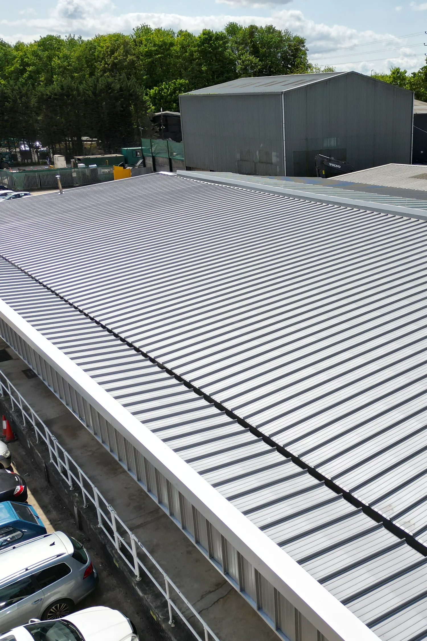 Standing seam metal roof refurbishment showing new corrugated panels installation
