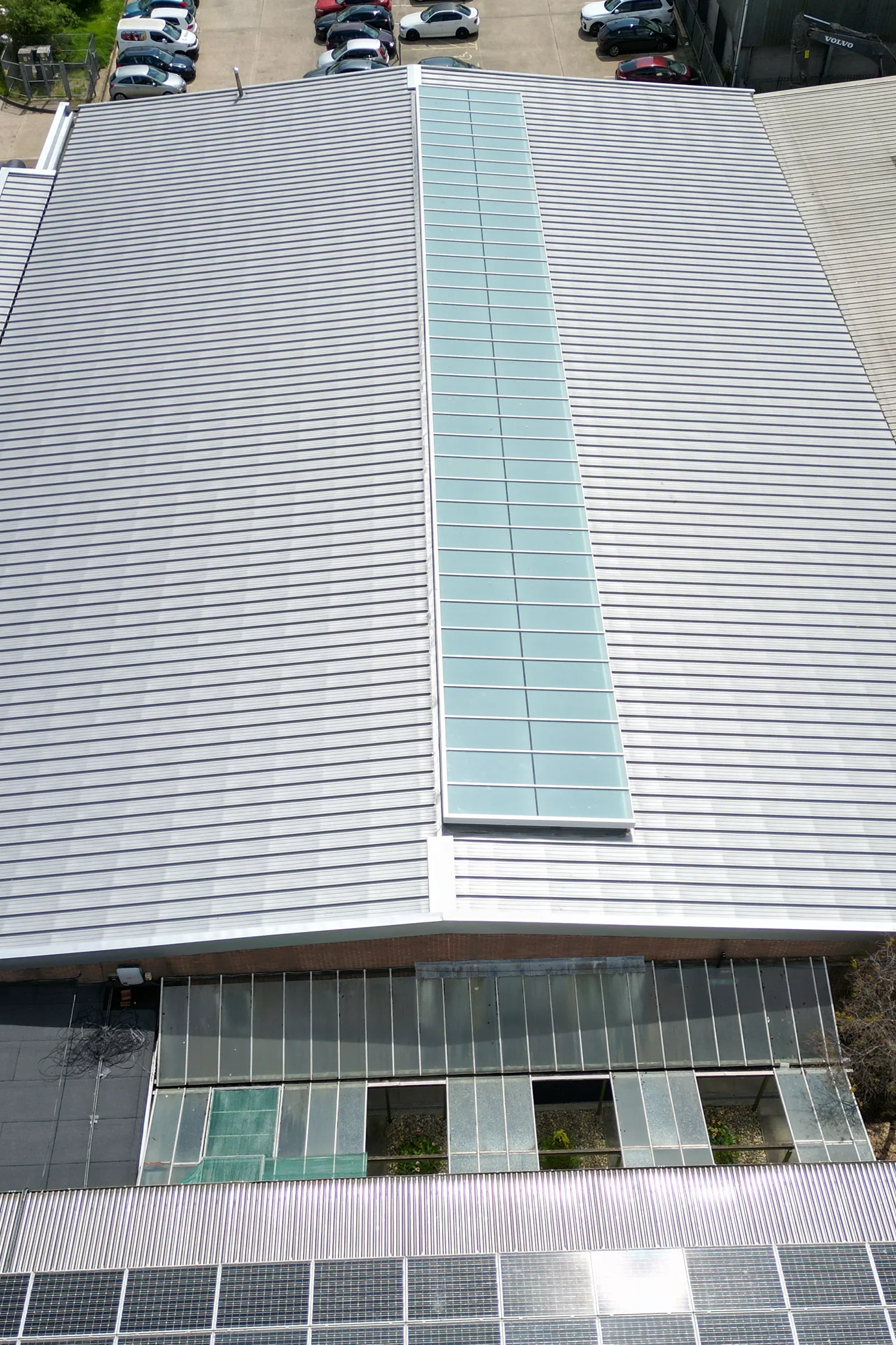 Modern building facade with standing seam metal roof and solar panels