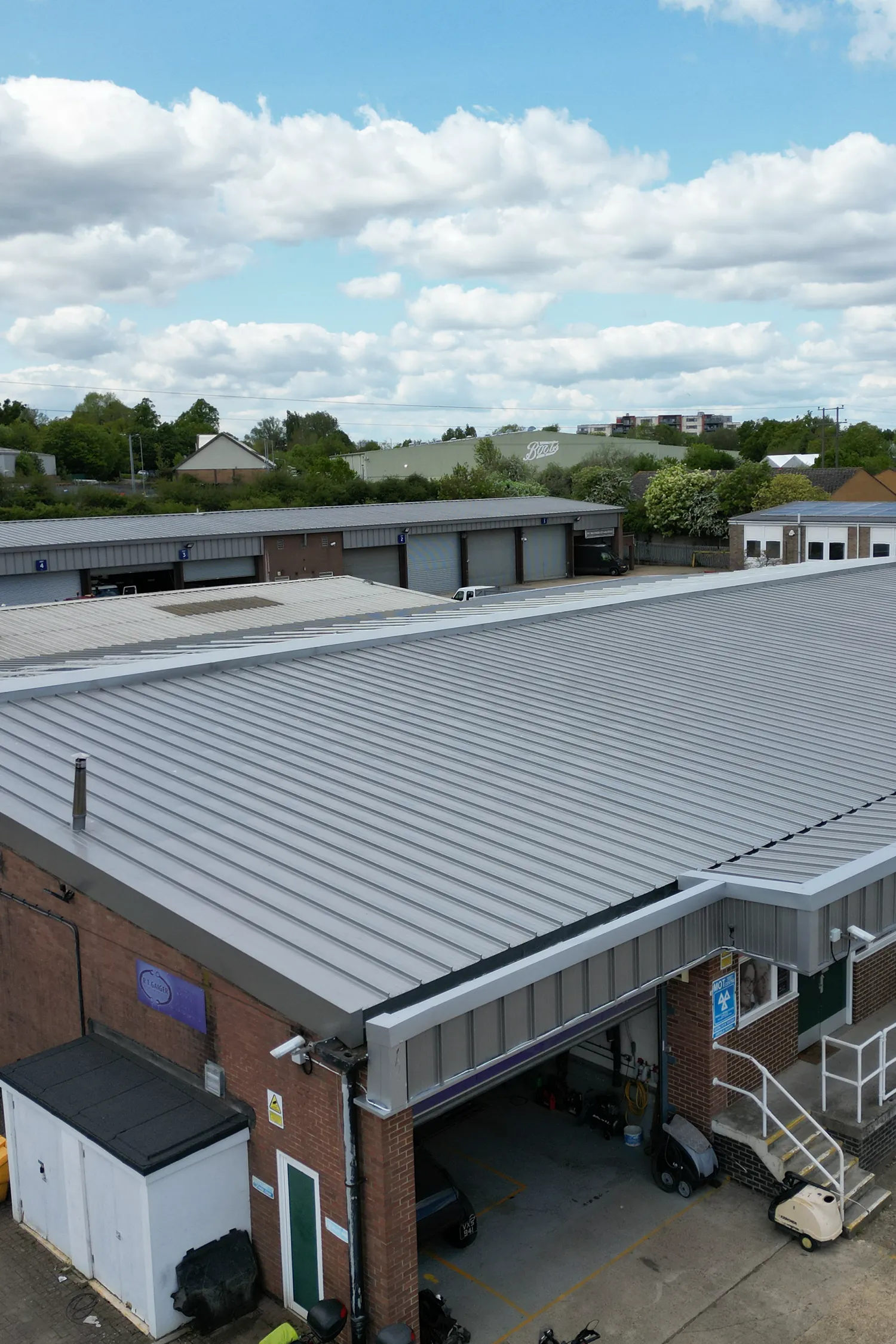 Industrial warehouse with standing seam metal roof refurbishment under blue sky