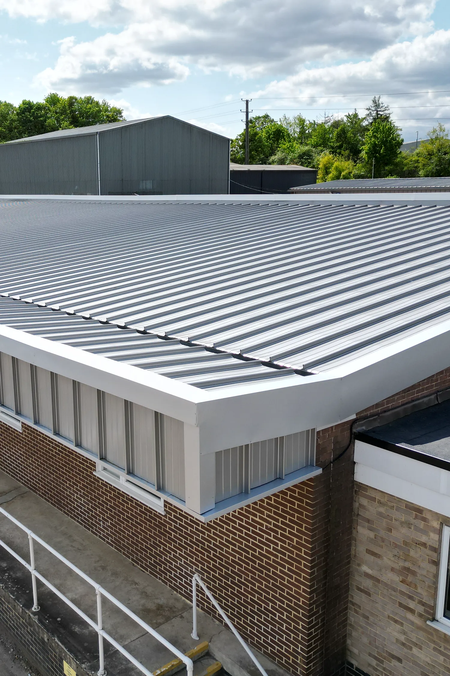 Standing seam metal roof refurbishment on brick building structure