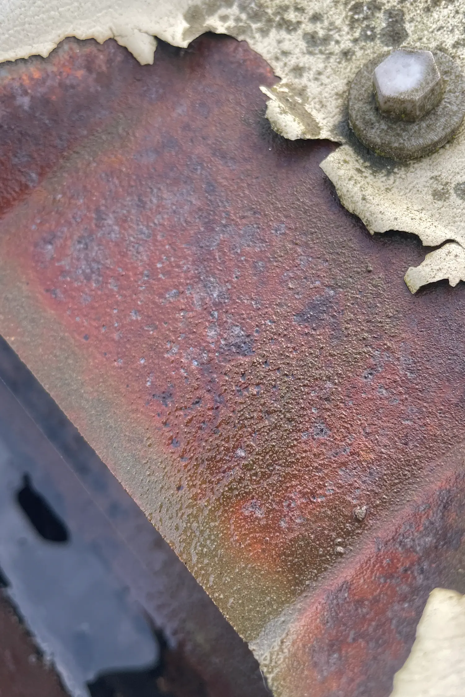 Weathered red brick with white mortar damage and metal bolt fixture