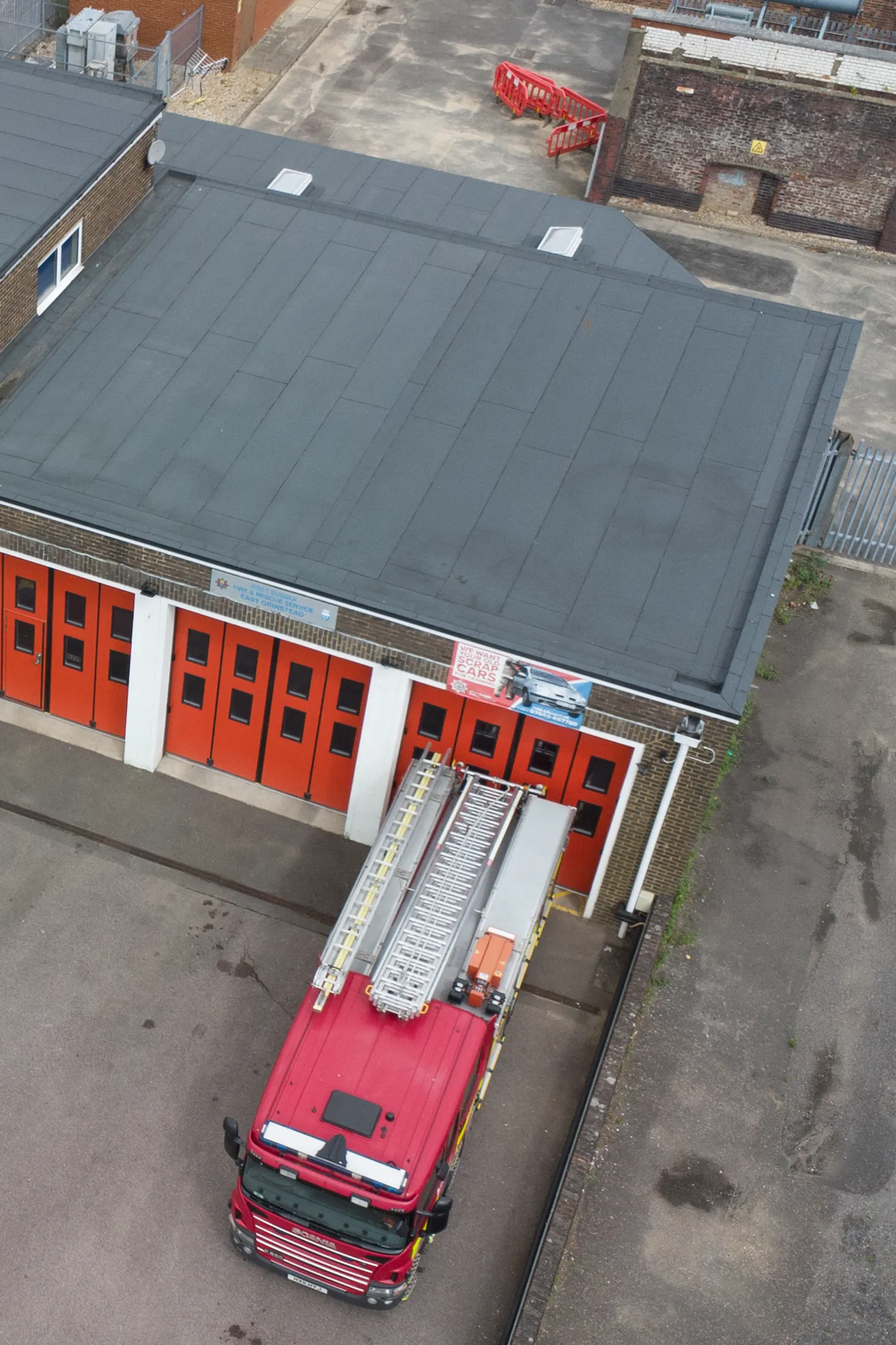 Aerial view fire station with red truck and solar panels roof