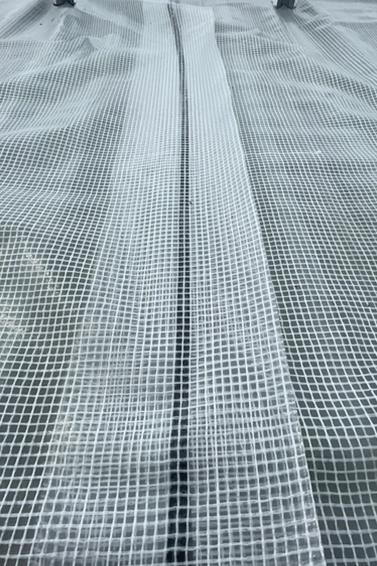 Aerial view of solar panel array with geometric grid pattern and central seam