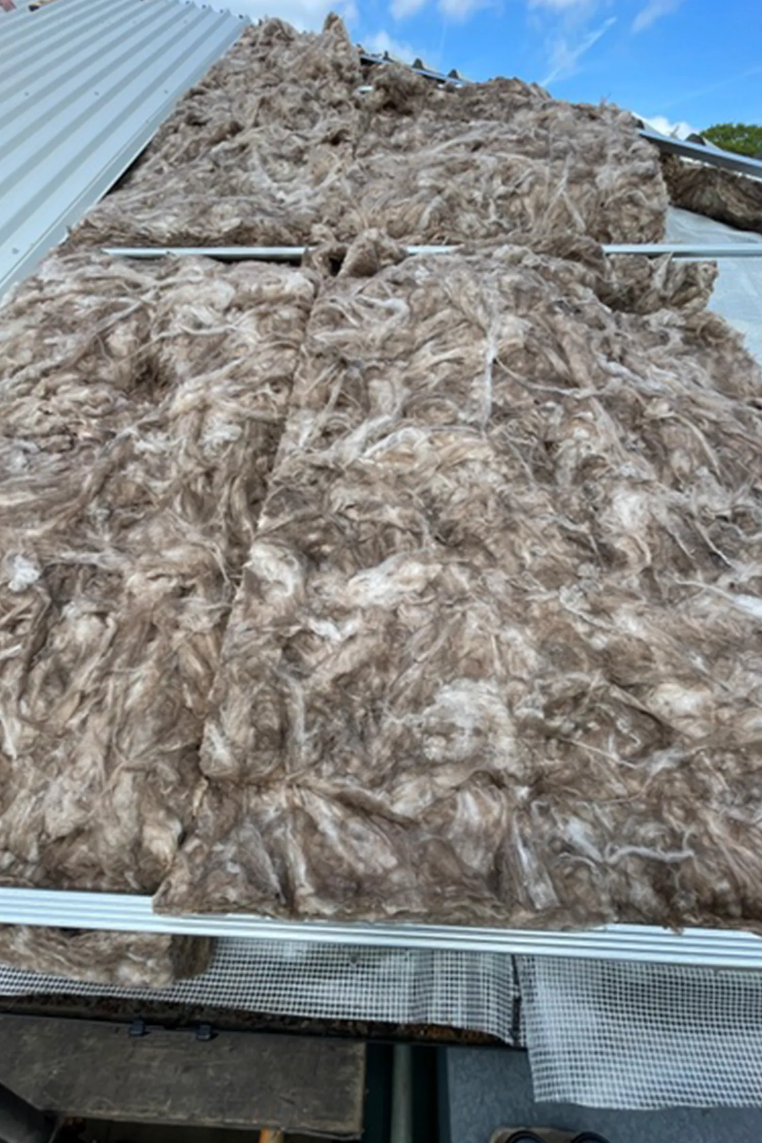 Large pile of insulation material stored under metal roof structure