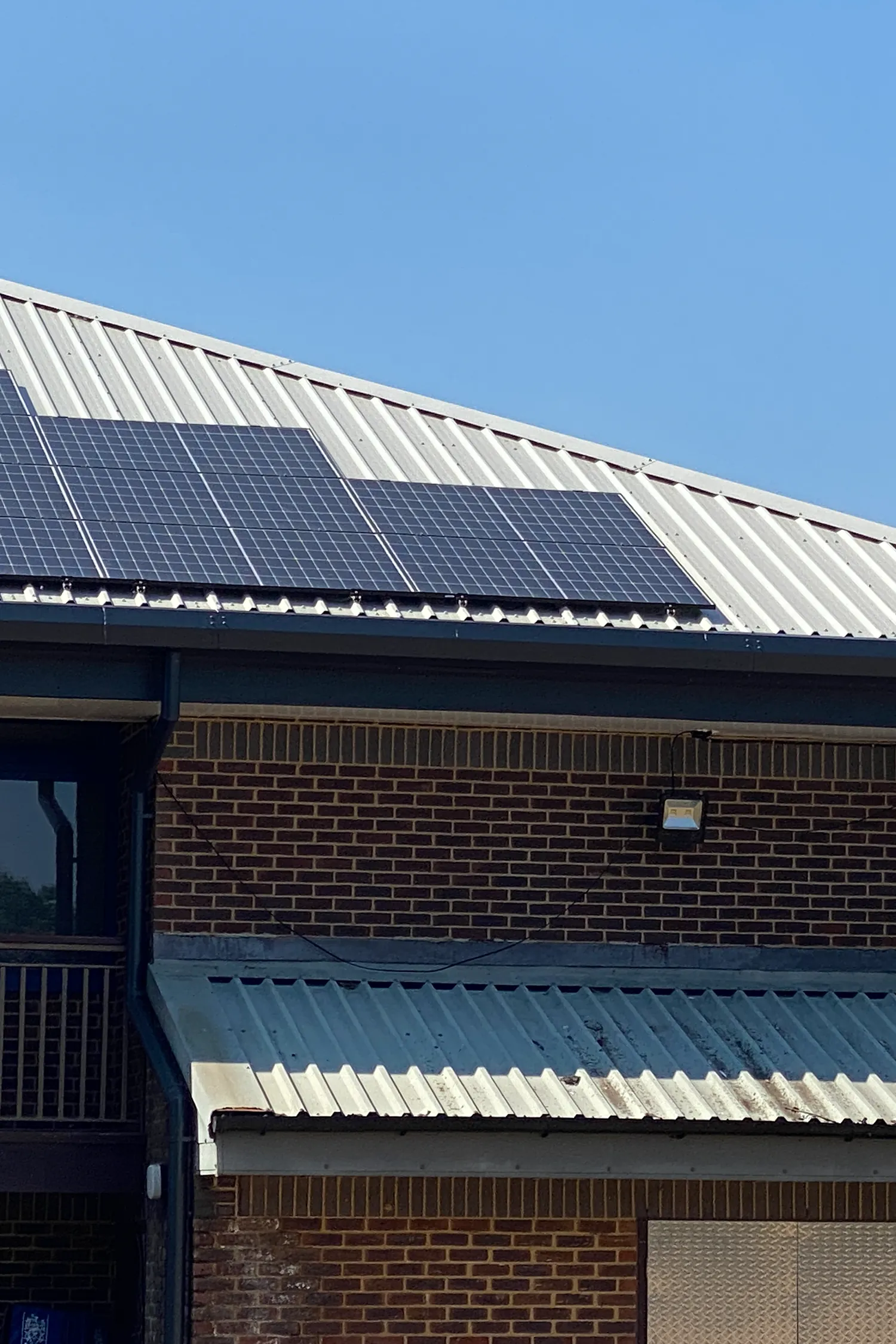 Solar panels installed on metal roof of brick building structure