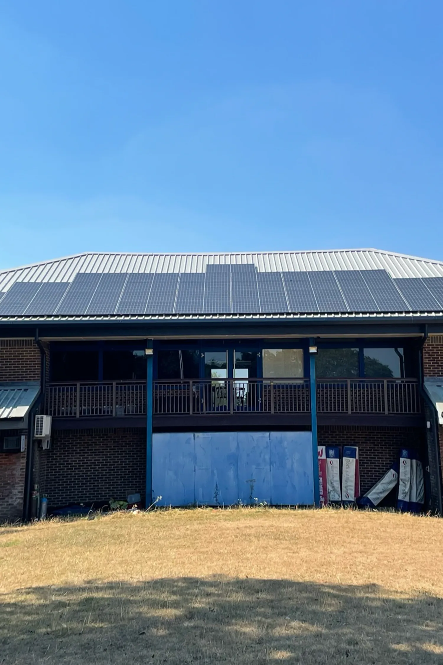 Modern brick building with solar panels and blue garage doors