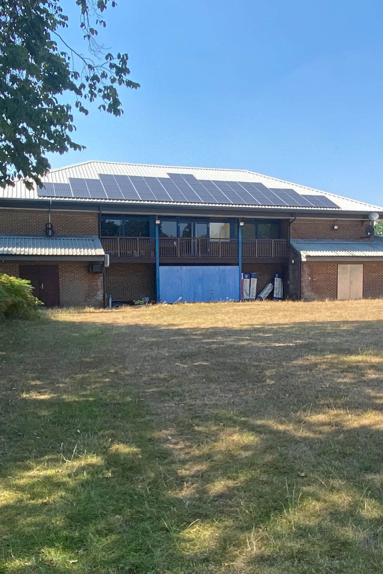Brick building with blue doors and solar panels on metal roof