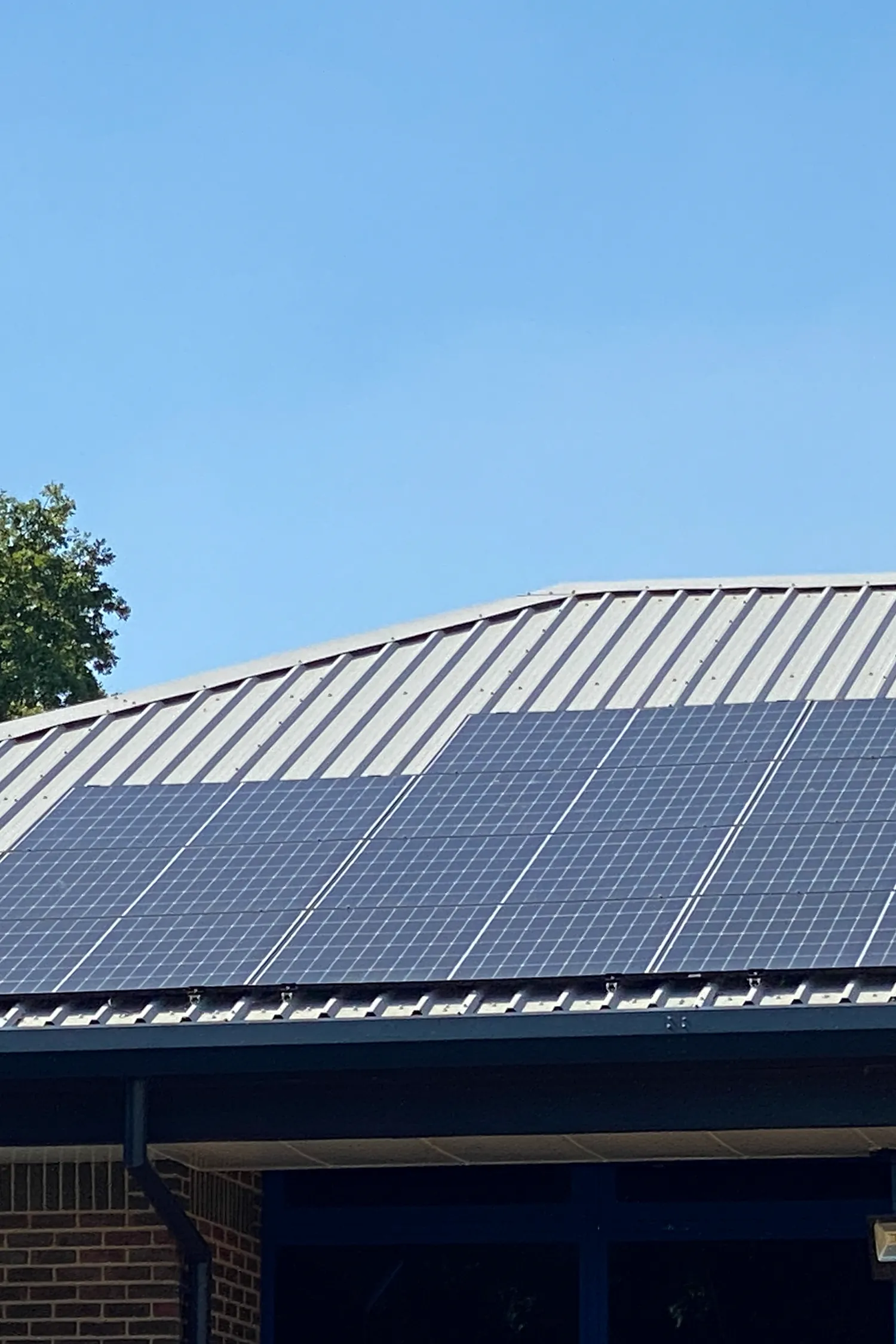 Solar panels installed on metal roof of Haslemere Rugby Club building