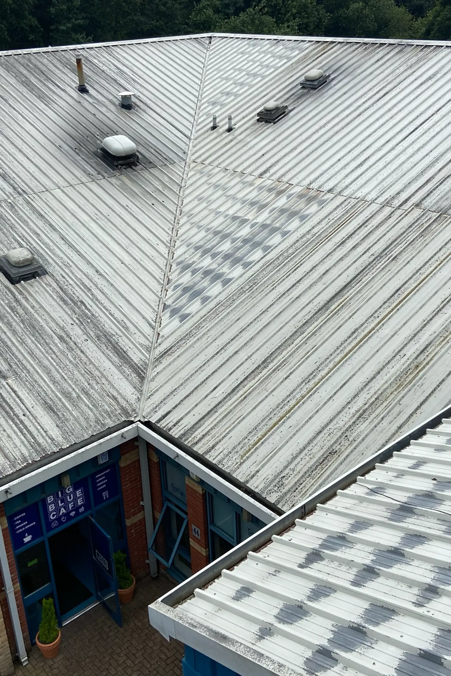 Metal roof with ventilation units and skylights on commercial building