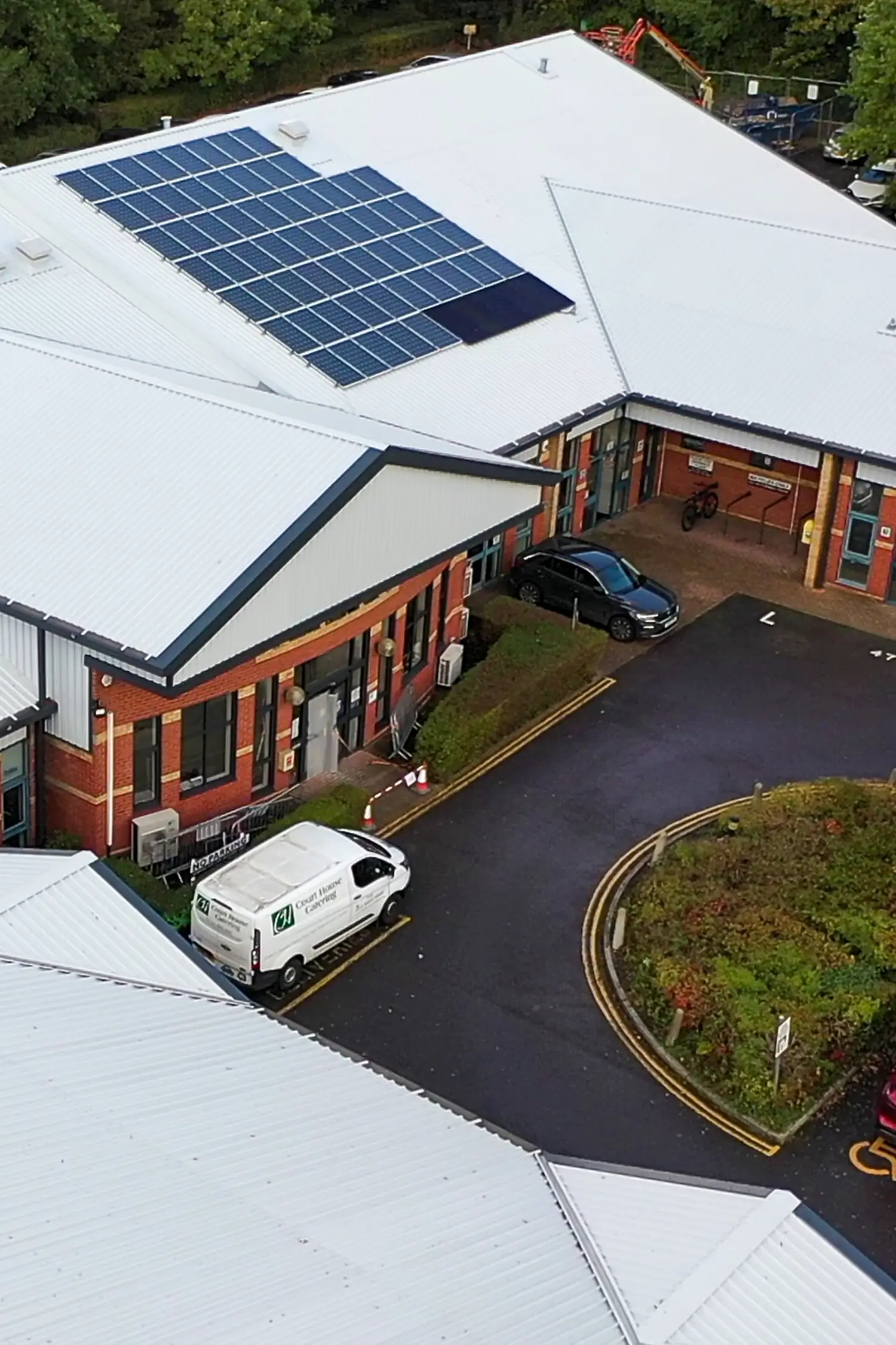Aerial view of business enterprise centre with solar panels and parked vehicles