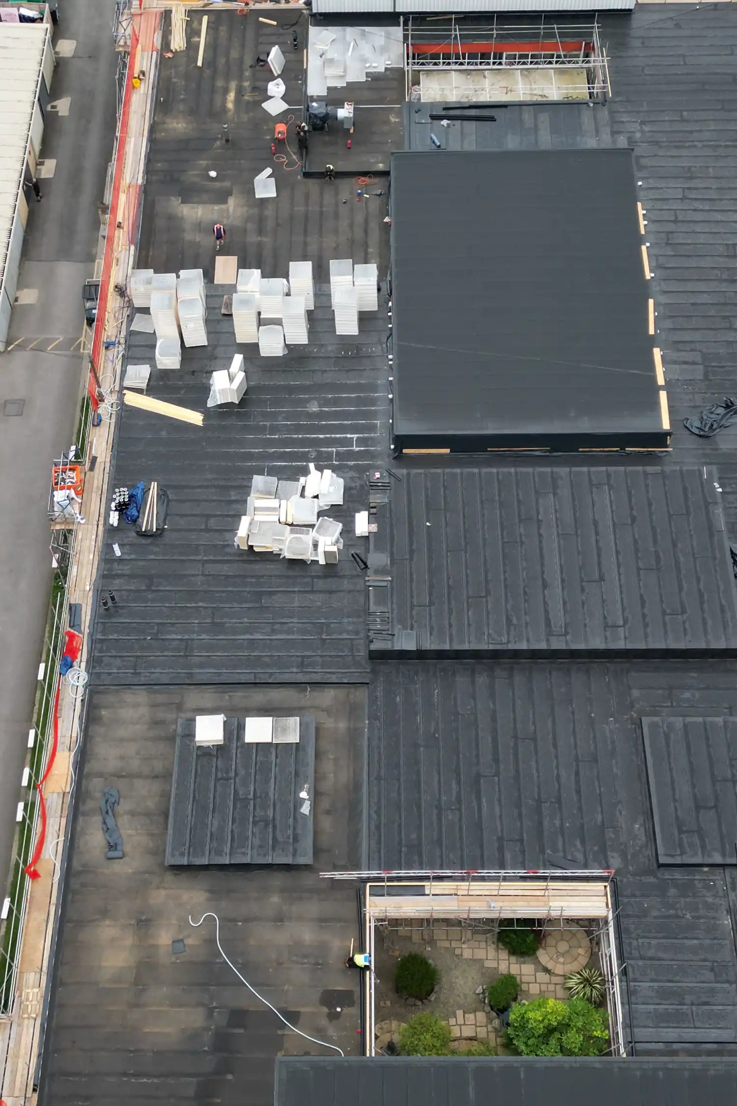Aerial view of rooftop construction site with white materials and workers