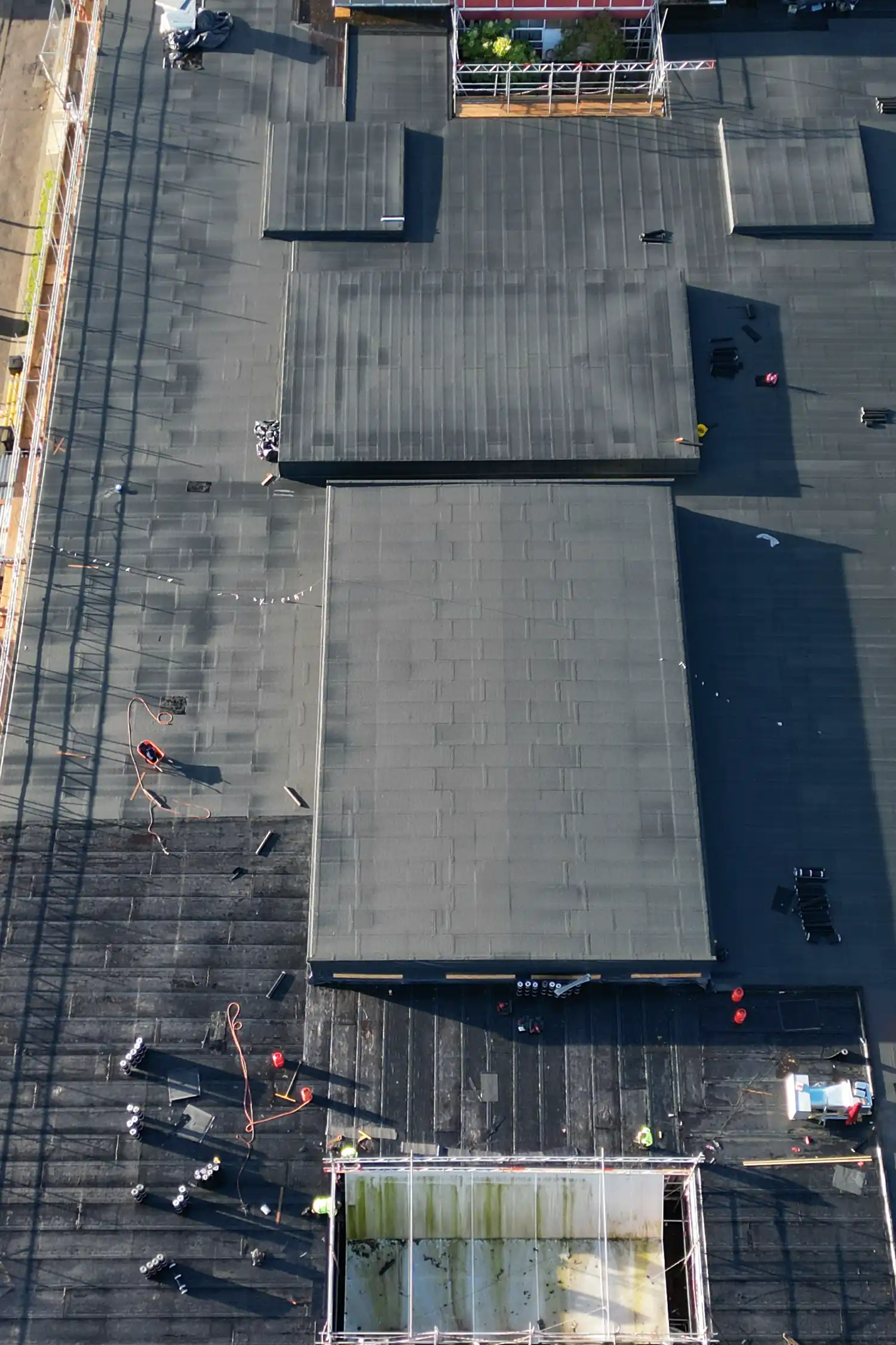 Aerial view of construction workers on flat rooftop during school renovation project
