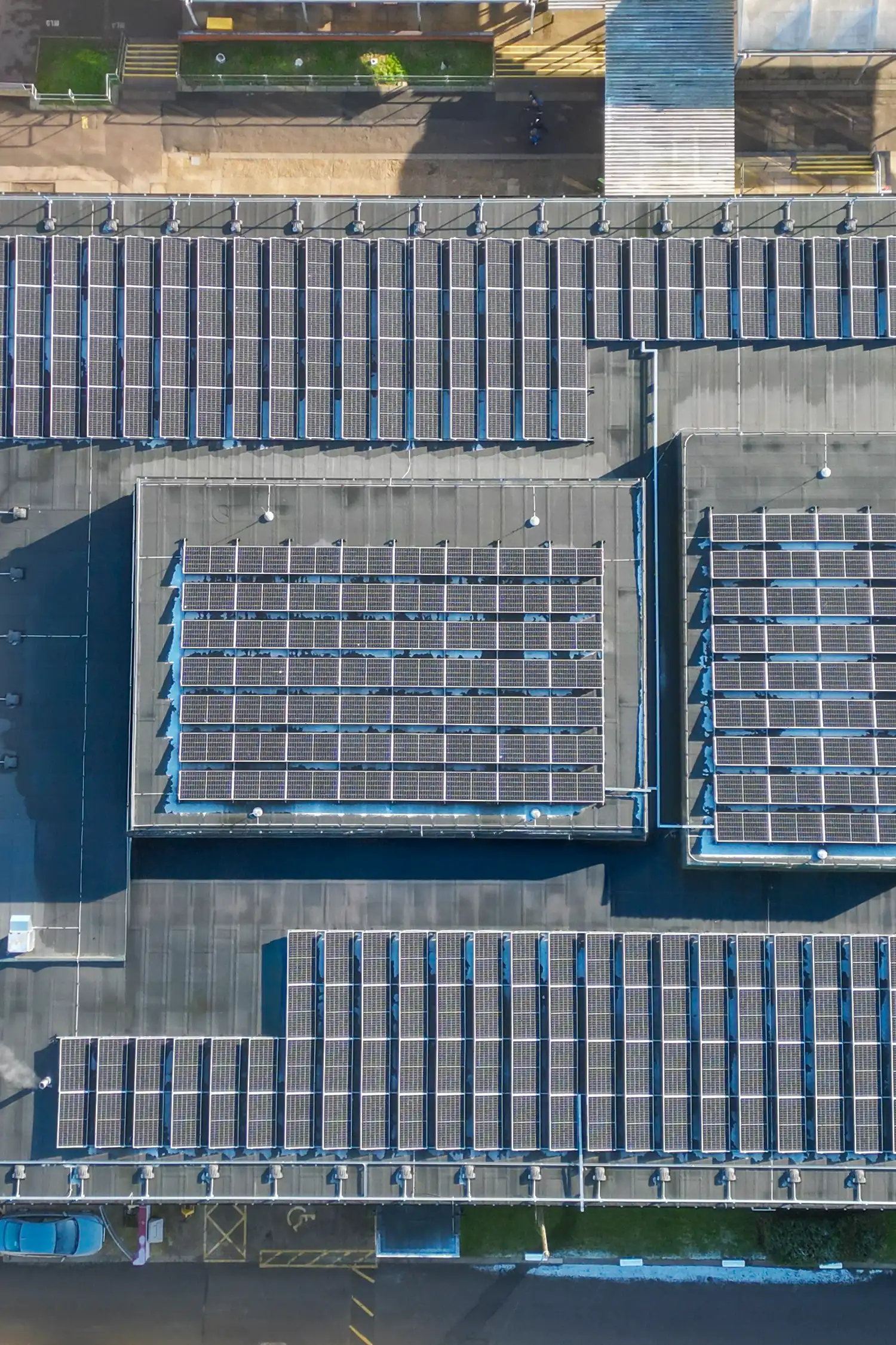 Aerial view of large-scale rooftop solar panel installation on school building