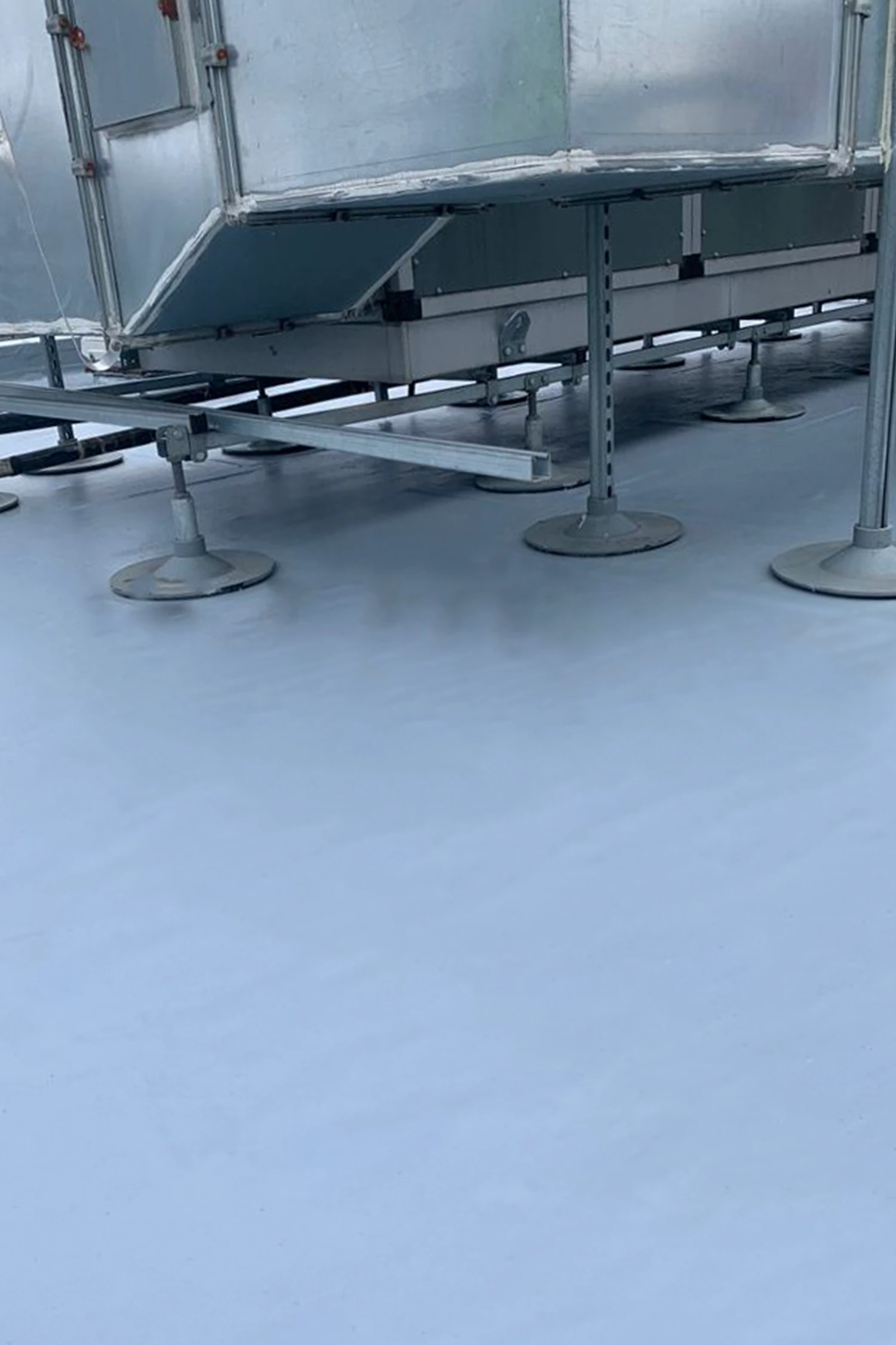Waterproofing membrane installation on hospital rooftop with metal framework supports