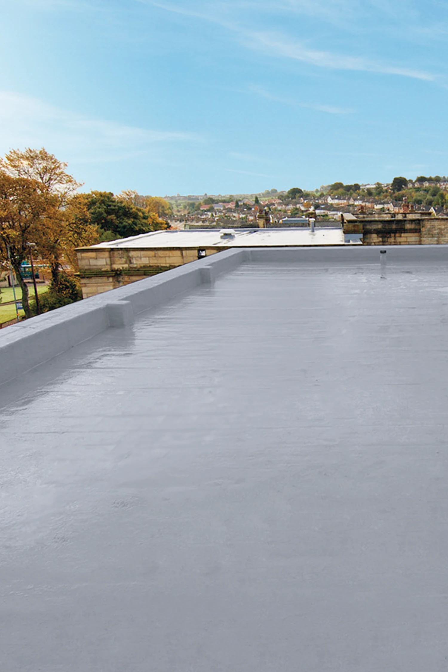 Flat roof waterproofing installation overlooking riverside town landscape