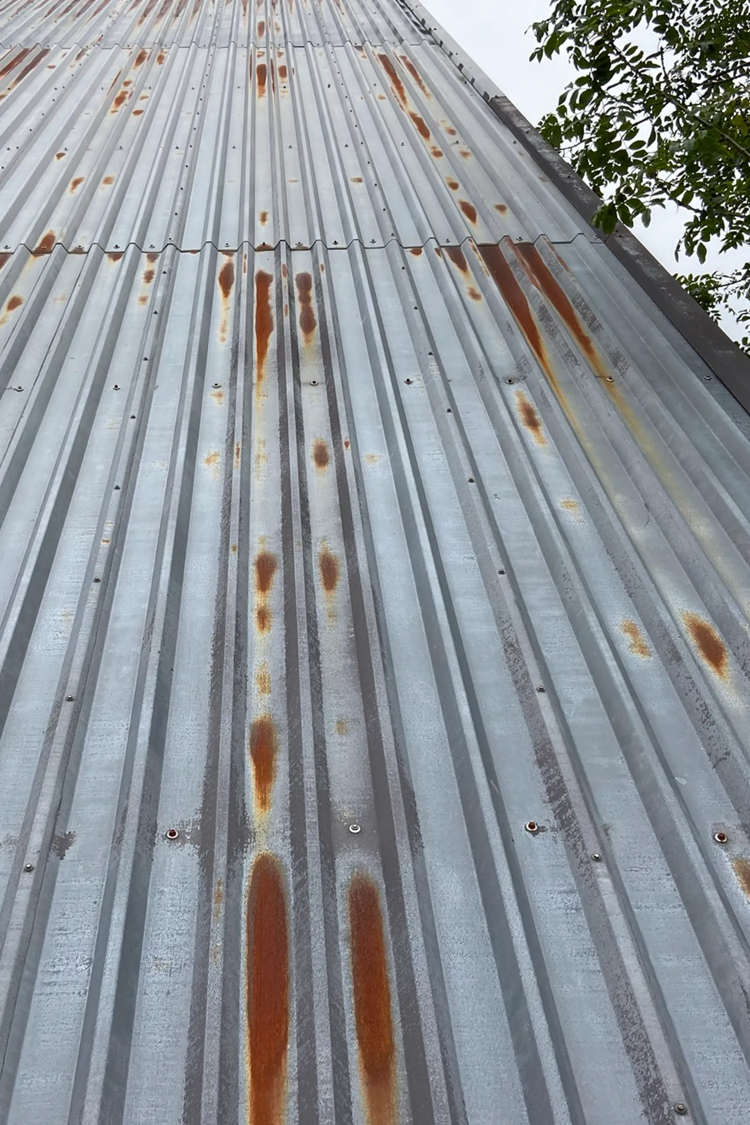 Corroded metal roof cladding with rust stains and weathering patterns