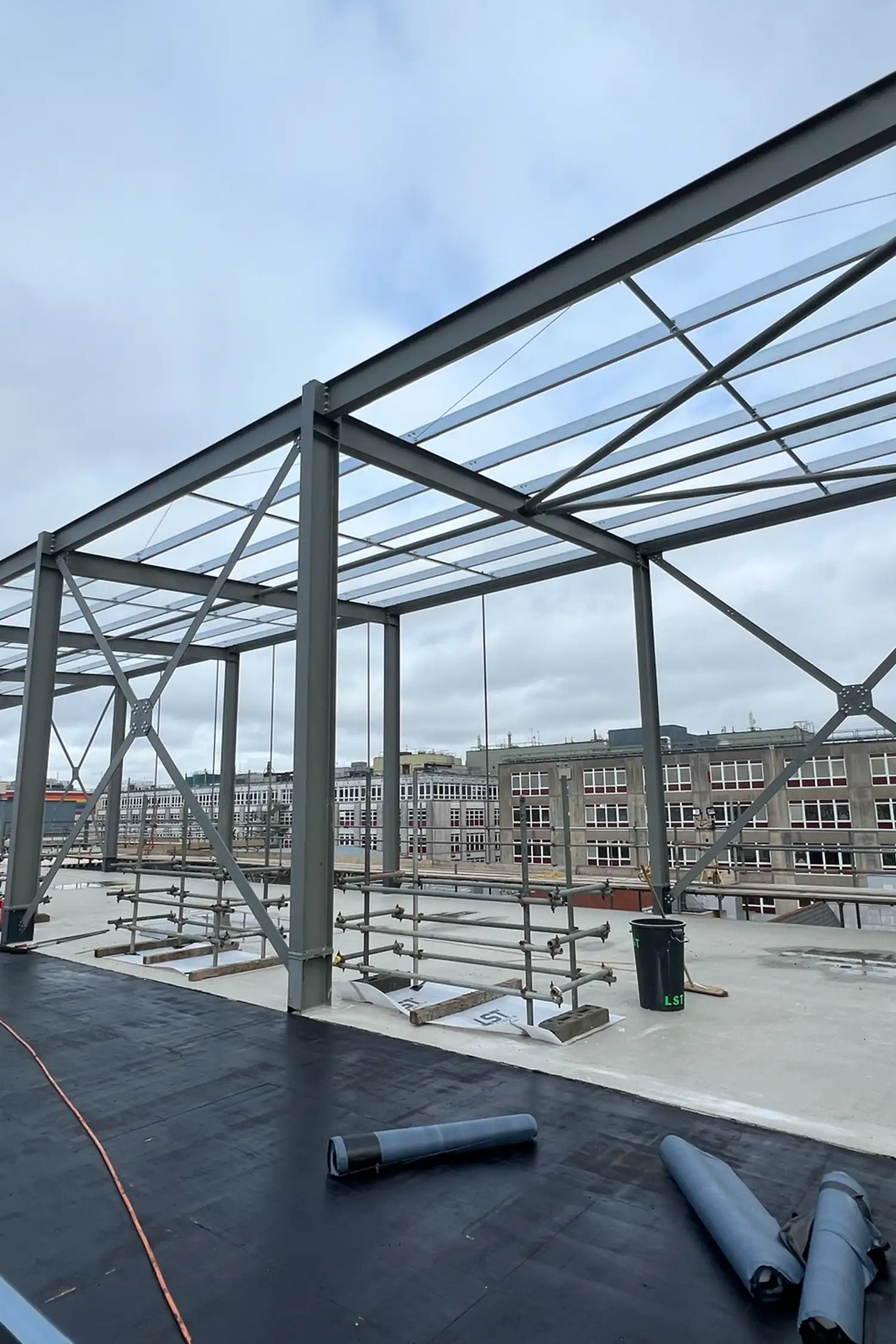 Steel frame structure with glass roof panels on hospital rooftop construction site