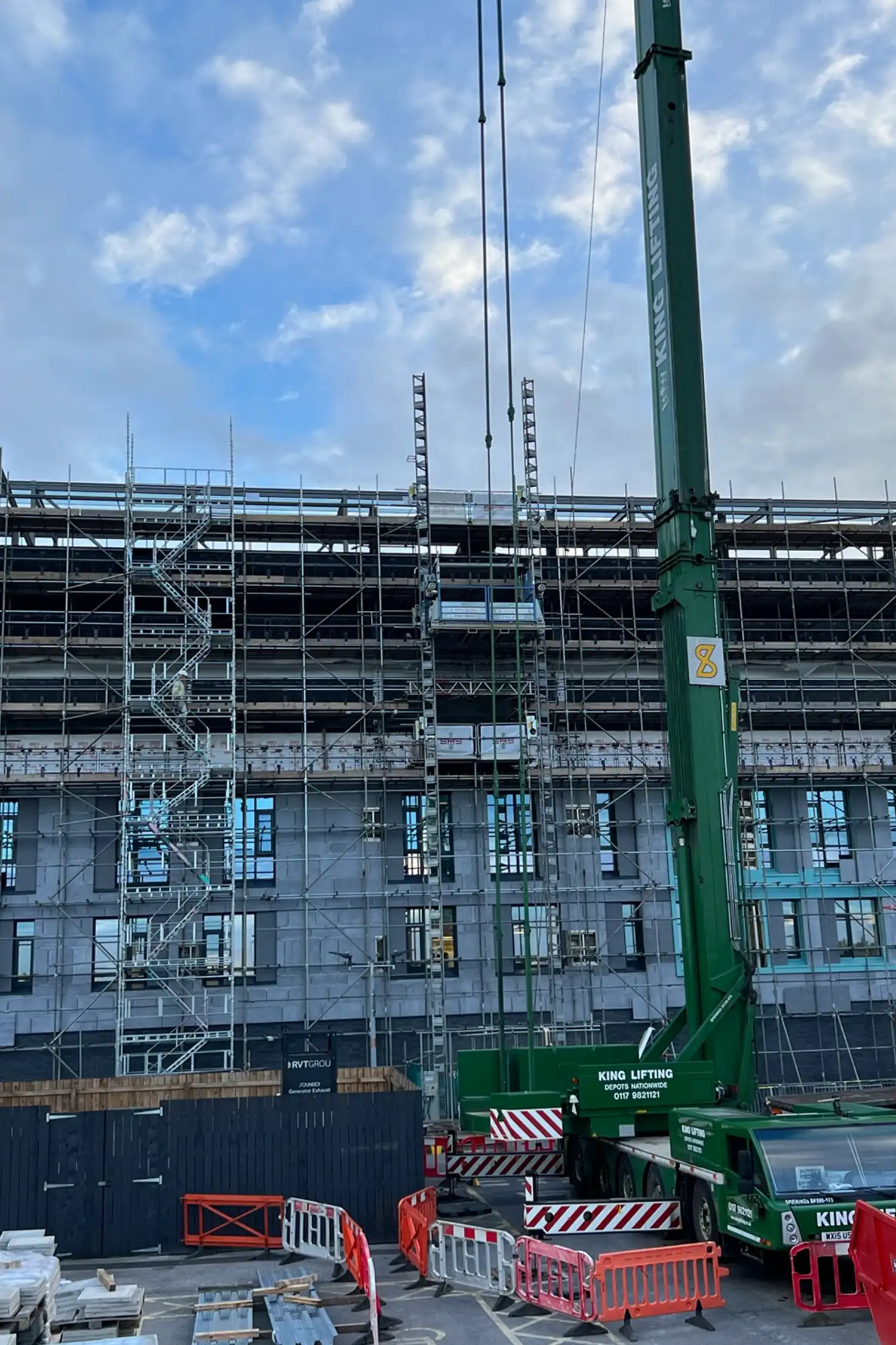 Construction site with green mobile crane and hospital building scaffolding Southampton