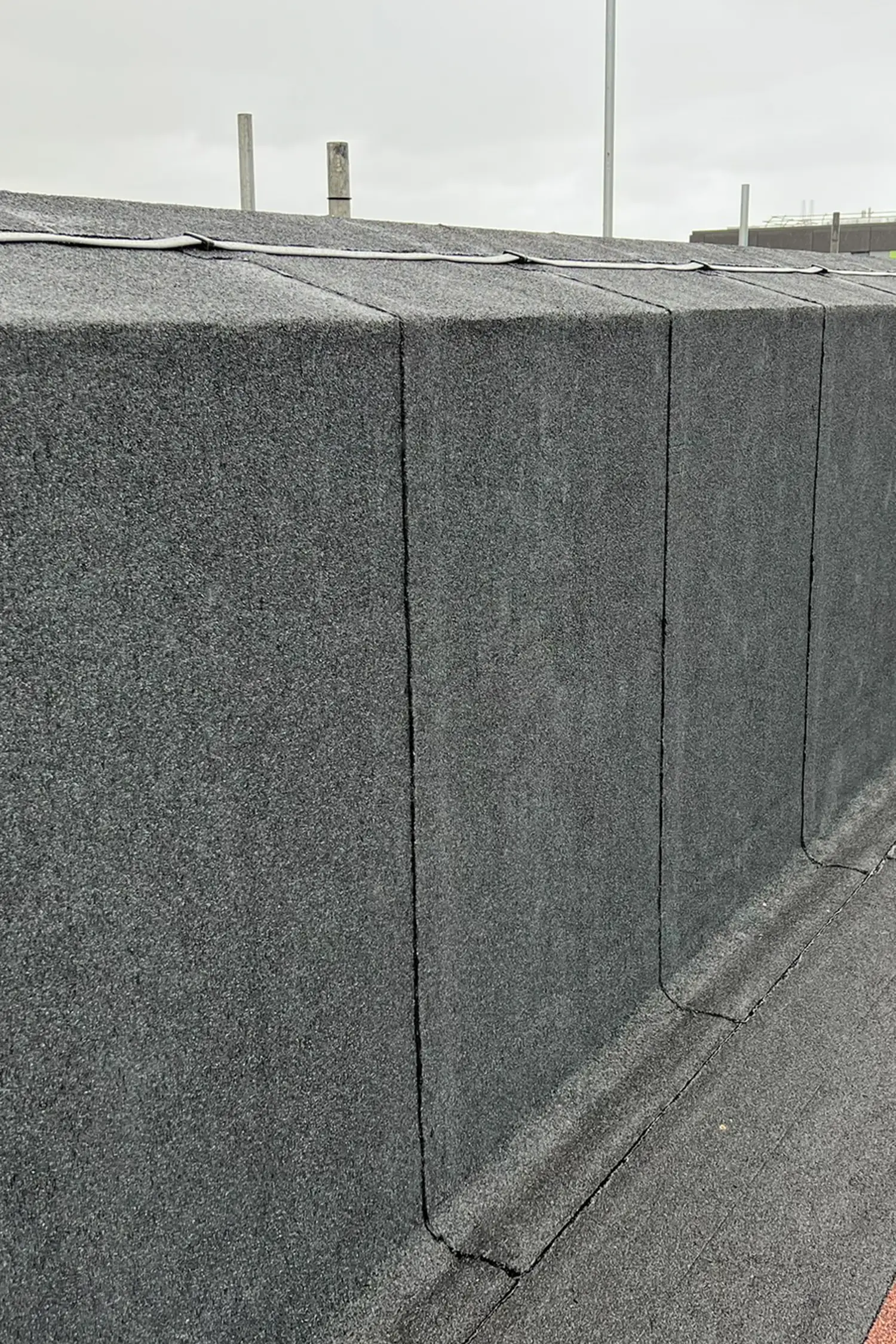 Concrete roof panels with vertical seams and metal posts on hospital building