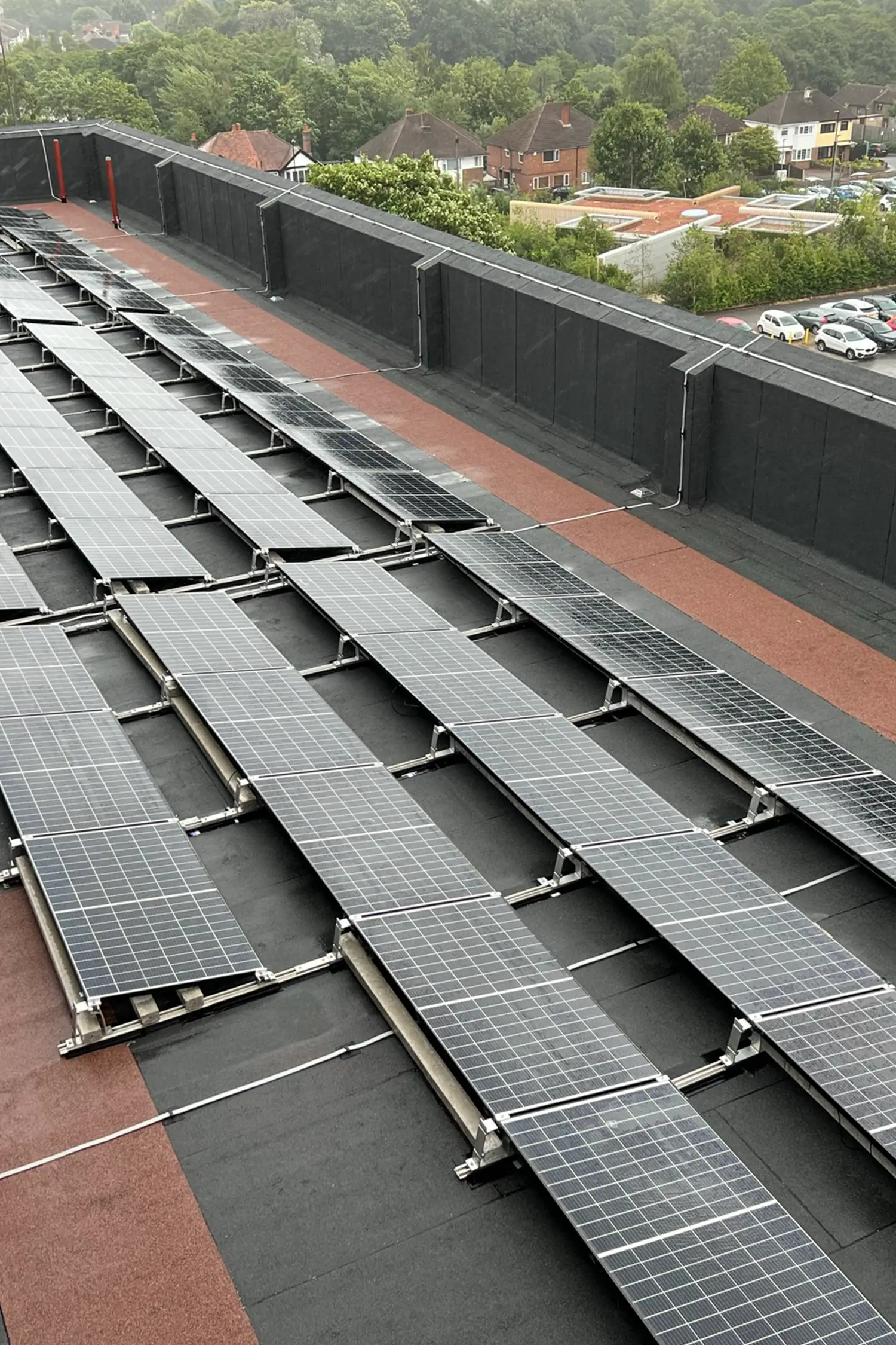 Solar panels installed on hospital building roof with residential area background