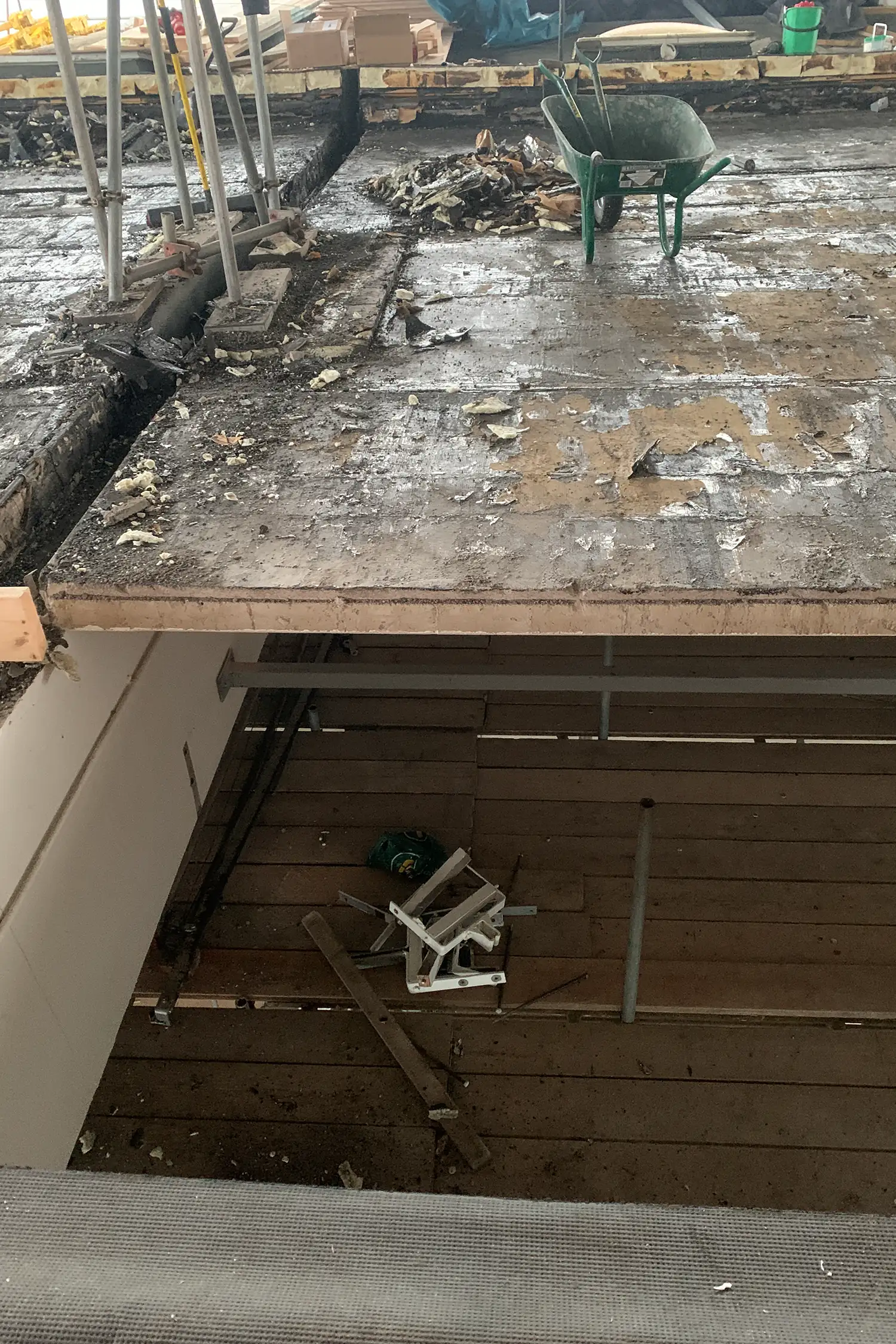 Construction site with concrete platform, debris, and green wheelbarrow equipment