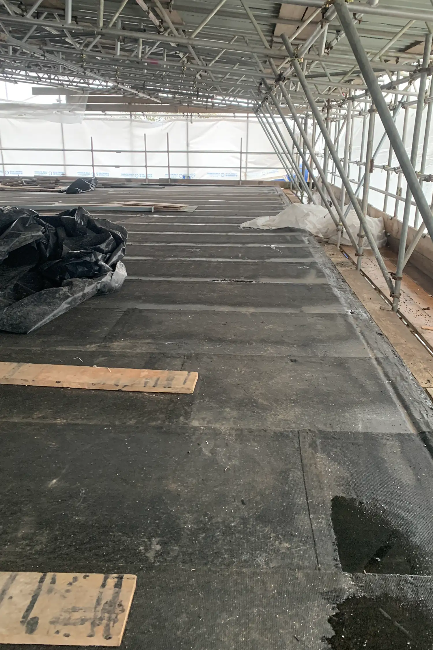 Interior greenhouse structure with concrete floor and metal scaffolding framework