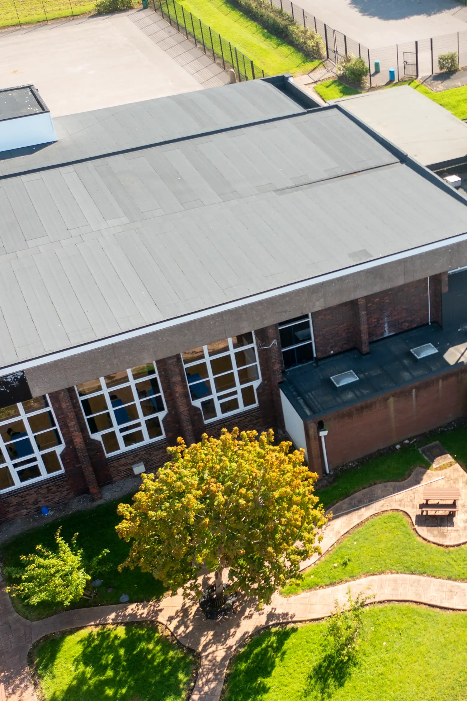 Aerial view brick building gray roof RAAC remediation replacement academy facility
