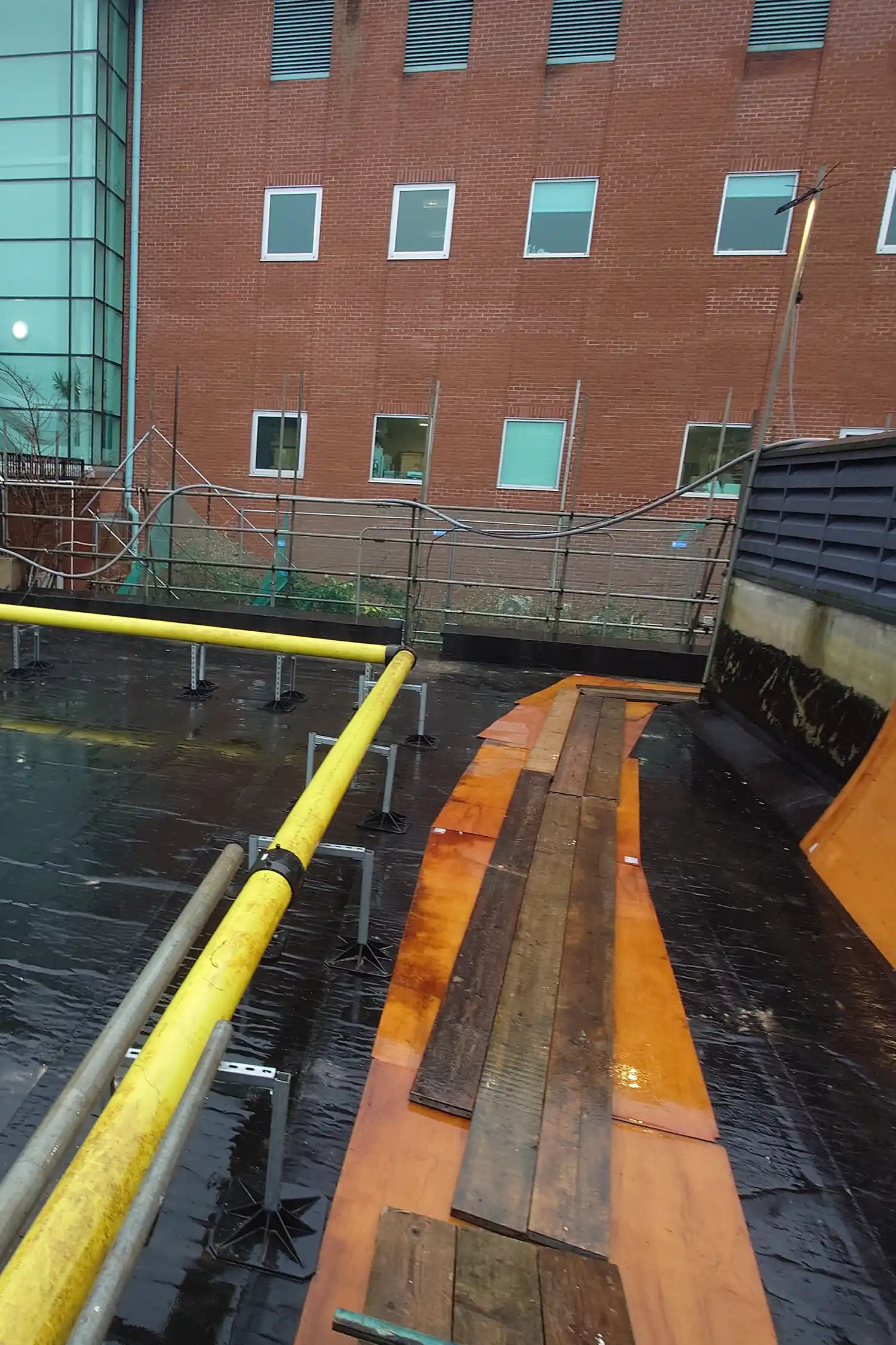 Waterfront building courtyard with yellow railing and wooden dock platform