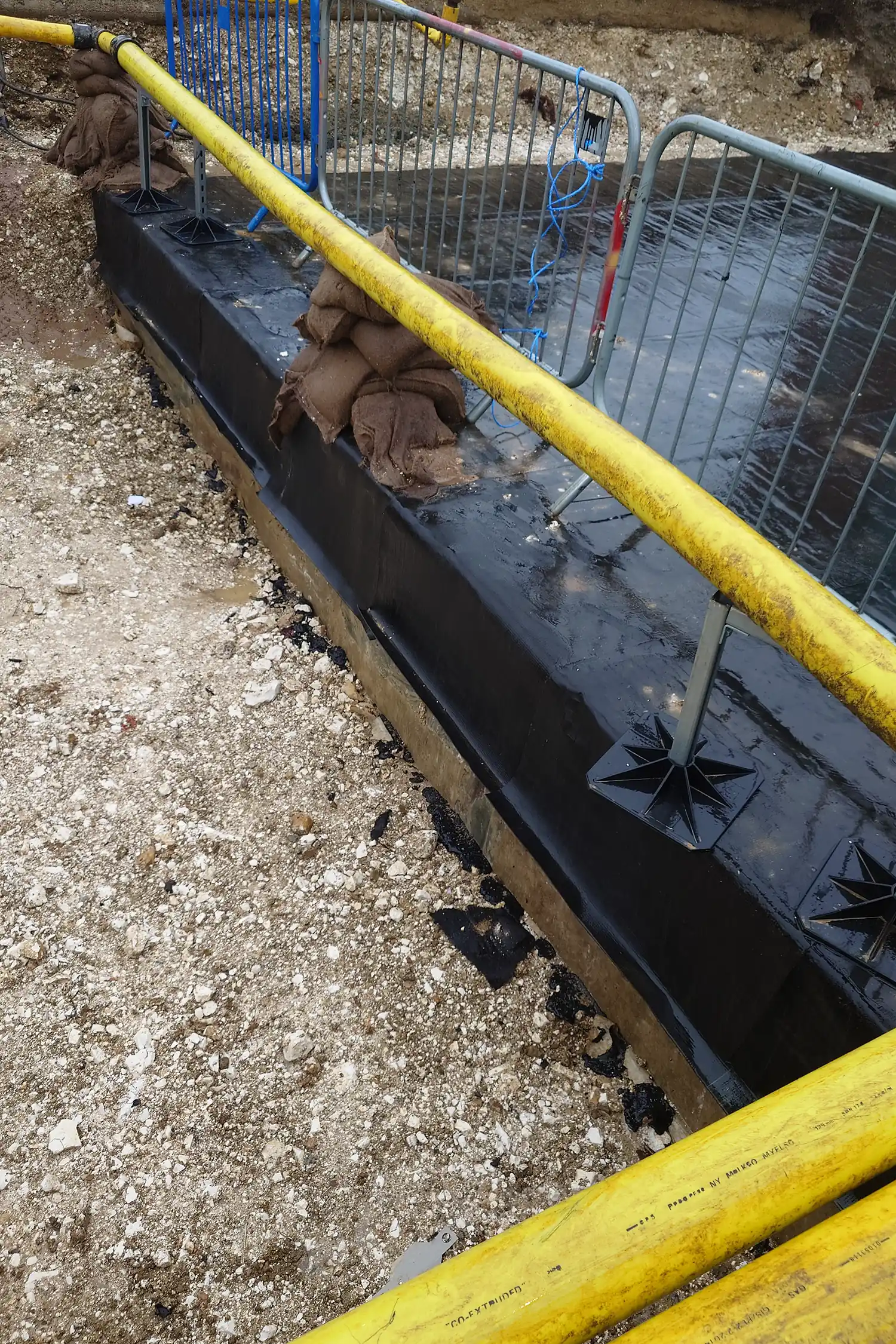 Construction site with yellow pipe railing and black protective barrier system
