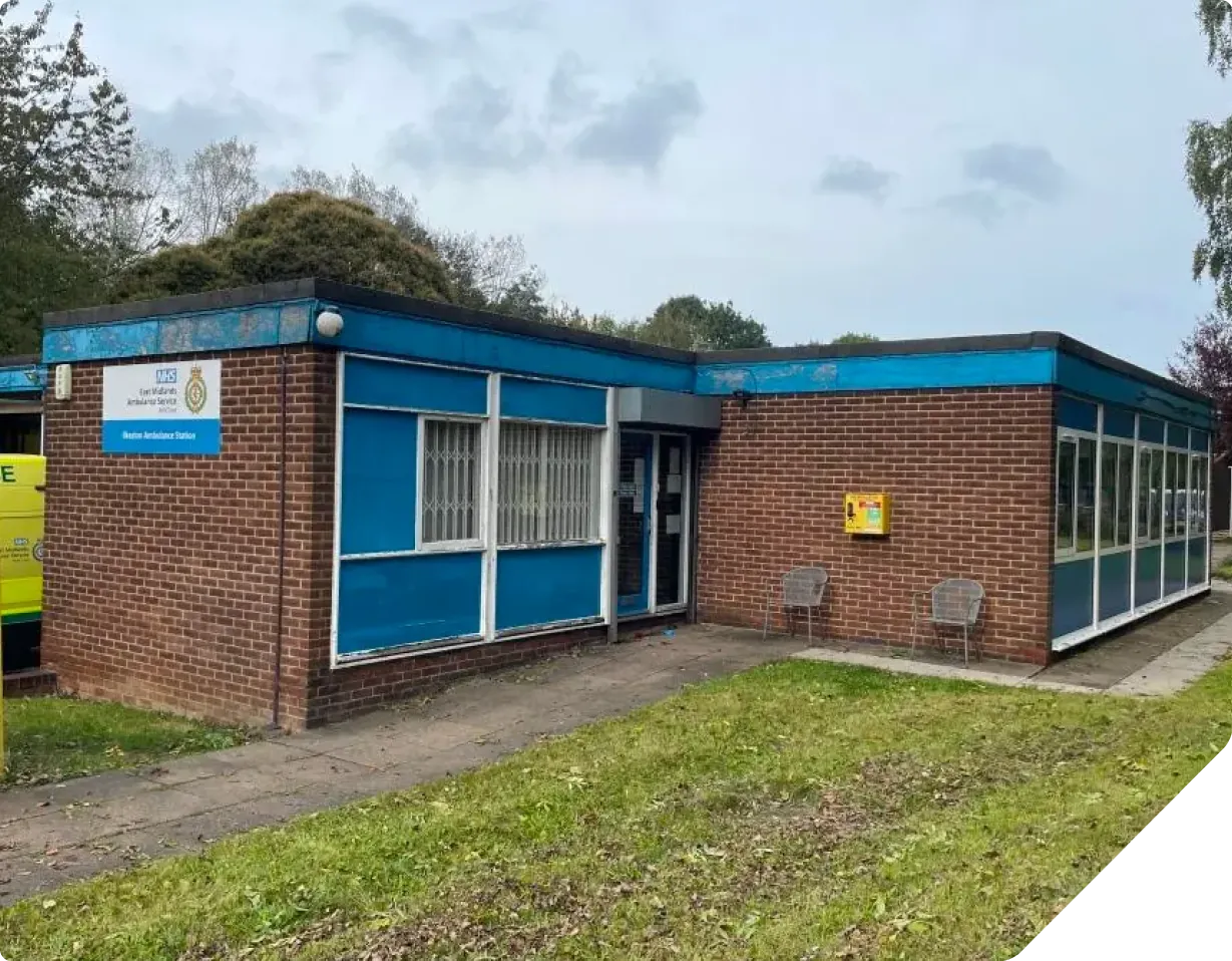 Brick ambulance station building with blue trim and large windows
