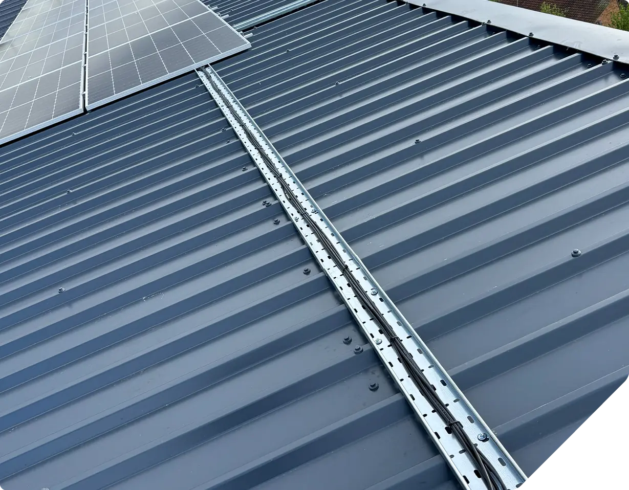 Metal corrugated roof with white aluminum solar panel mounting rails installed