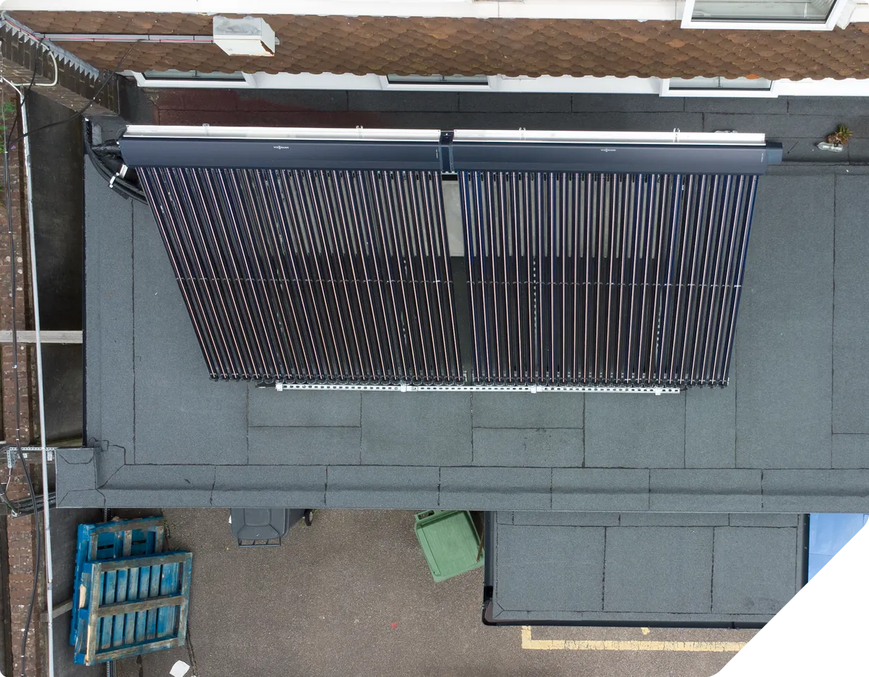 Overhead view of two solar thermal collector panels mounted on flat roof