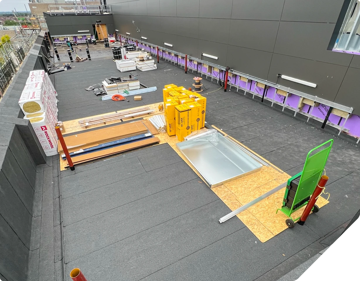 Construction site on hospital rooftop with yellow safety equipment and wooden framing materials