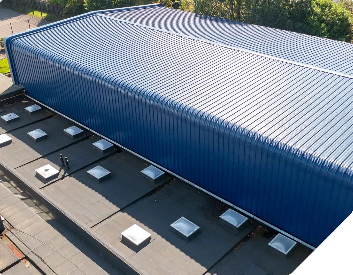 Aerial view blue corrugated metal roof with skylights and ventilation units