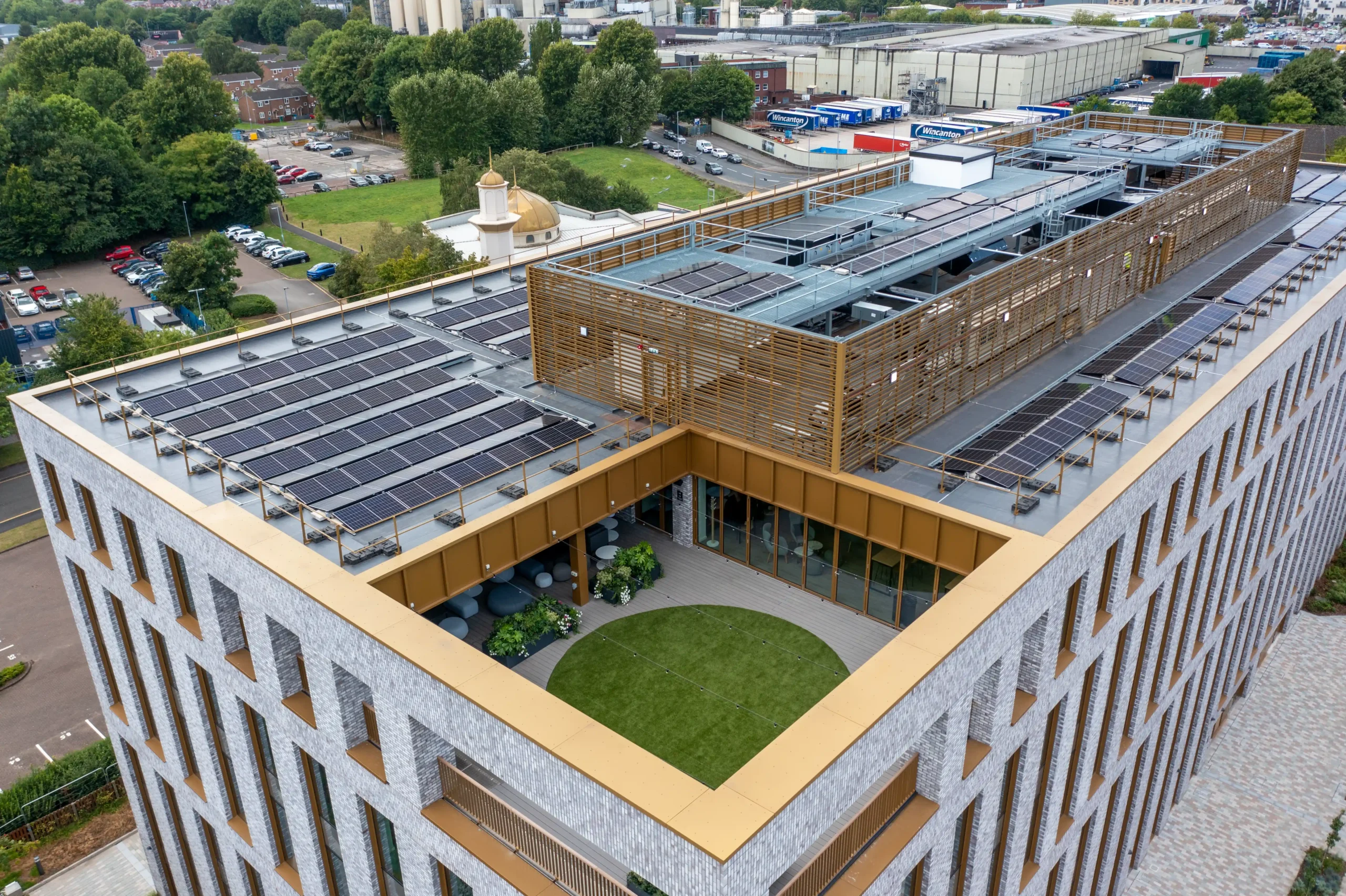 Modern building rooftop with solar panels and central courtyard garden