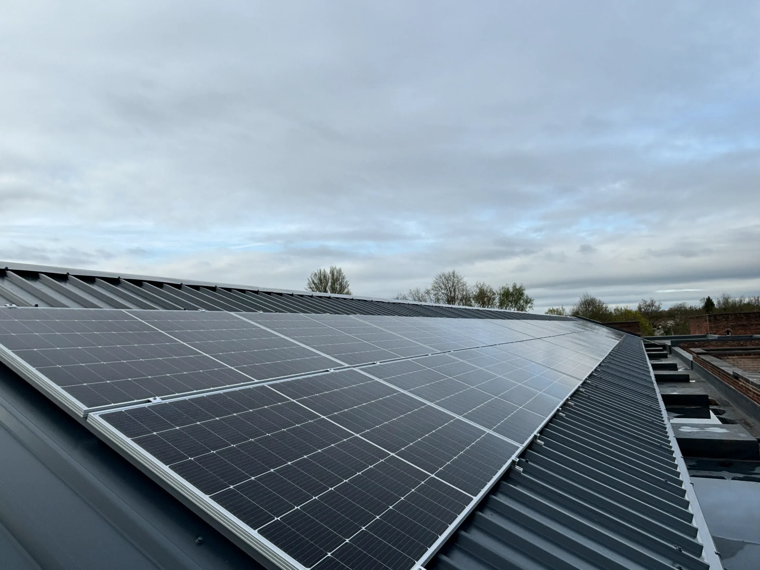 Large rooftop solar panel array installed on industrial building roof